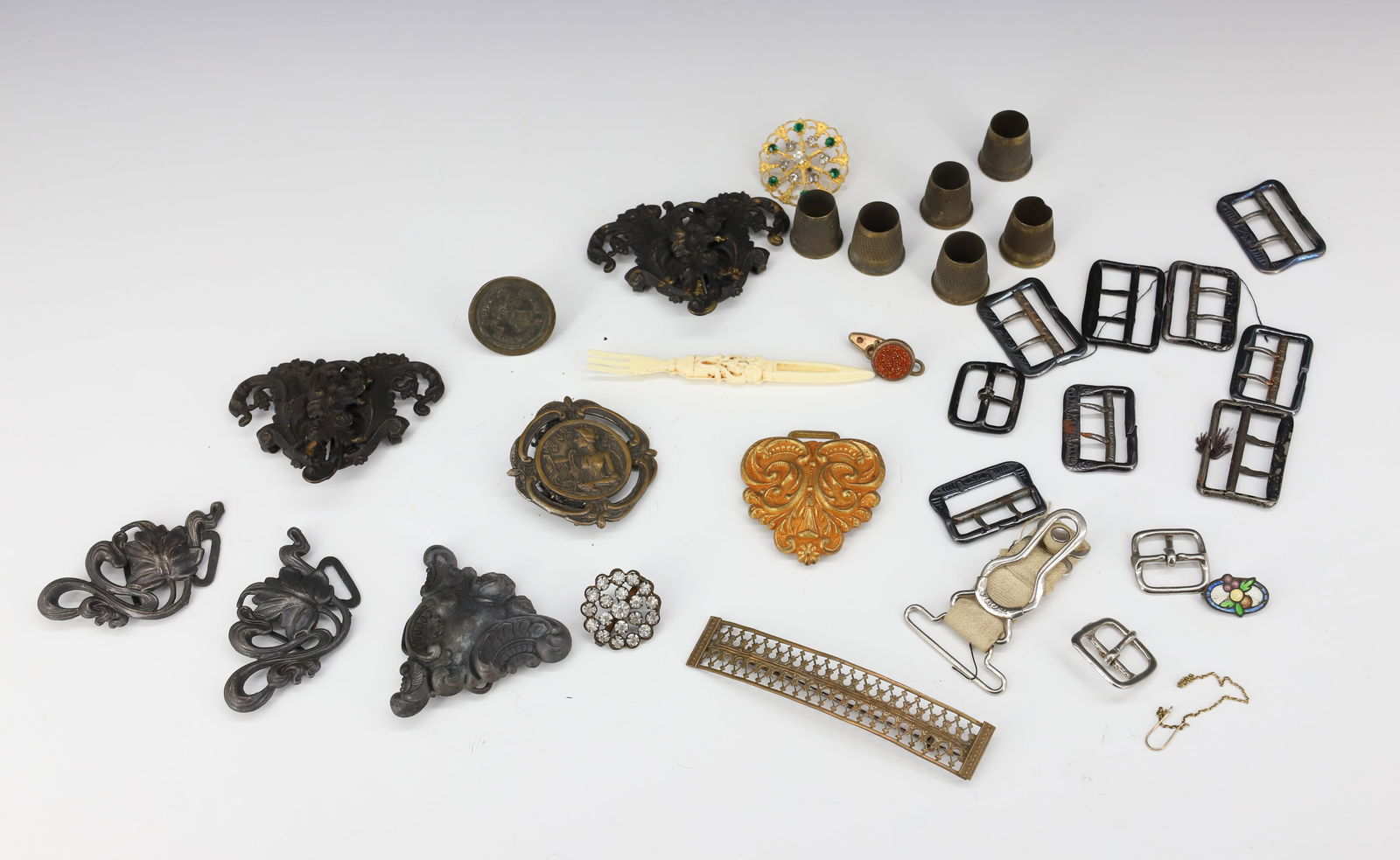 LOT OF VICTORIAN BUCKLES, THIMBLES, MORE: VARIOUS PRESSED METAL BUCKLES, BRASS THIMBLES AND SMALLS.