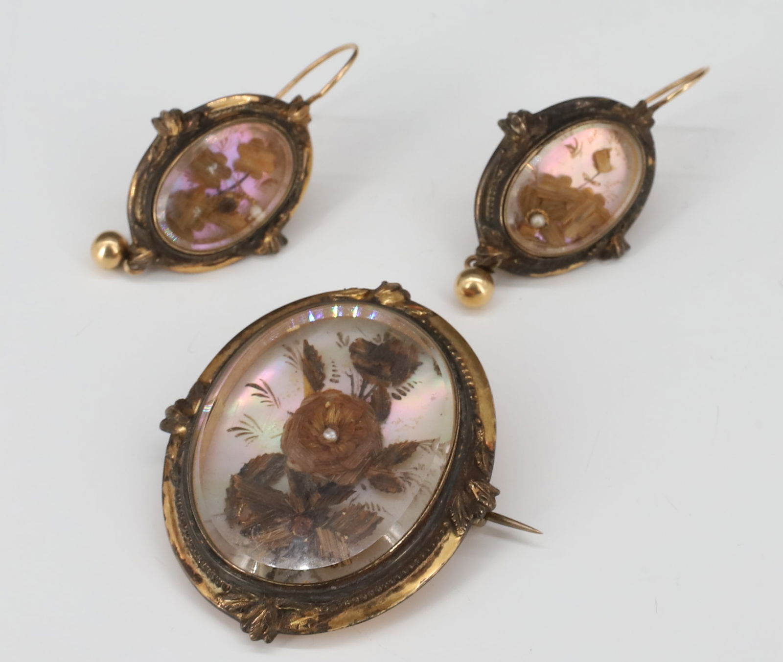 10K GOLD VICTORIAN JEWELRY HAIR SUITE: BROOCH WITH MOTHER OF PEARL DECORATED WITH HAIR HANDWORK, MATCHING PAIR OF EARRINGS BROOCH 1 3/4" X 1 3/8",EARRINGS 1 1/2" X 3/4{" TOTAL WEIGHT 10.7 DWT GOLD TESTED TO BE 10/12K GOLD PLEASE