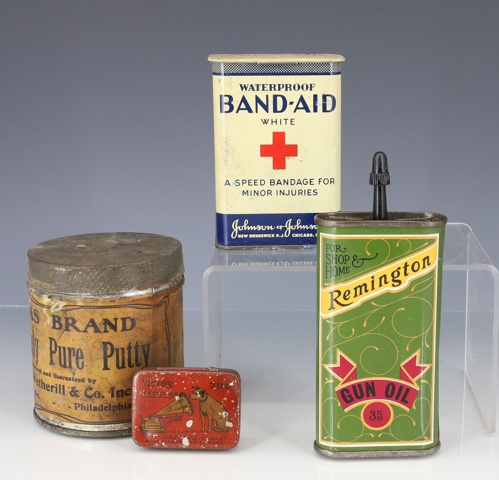 REMINGTON GUN OIL TIN AND MORE: OIL TIN 4" H. (FILLED). WITH, TIN BAND-AID, VICTOR NEEDLES AND "ATLAS BRAND ABSOLUTELY PURE PUTTY" PLEASE READ CAREFULLY - TEMS MUST BE PAID FOR THROUGH LIVE AUCTIONEERS OR WITH CASH OR CHECK IN PERSO