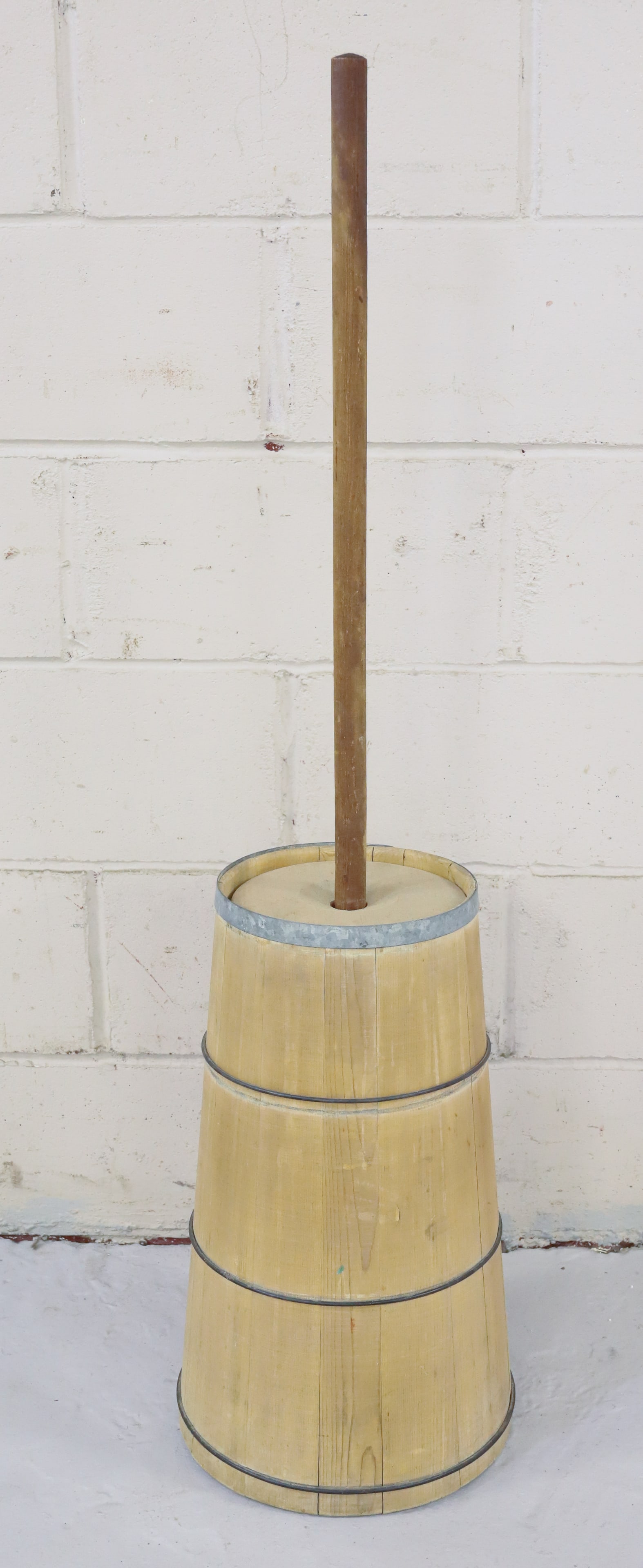 WOODEN BUTTER CHURN: TAPERED SIDES WITH WIRE BANDING. BASE 20" AND TOTAL HEIGHT W/ DASHER 46" H. PLEASE READ CAREFULLY - TEMS MUST BE PAID FOR THROUGH LIVE AUCTIONEERS OR WITH CASH OR CHECK IN PERSON - Terms for