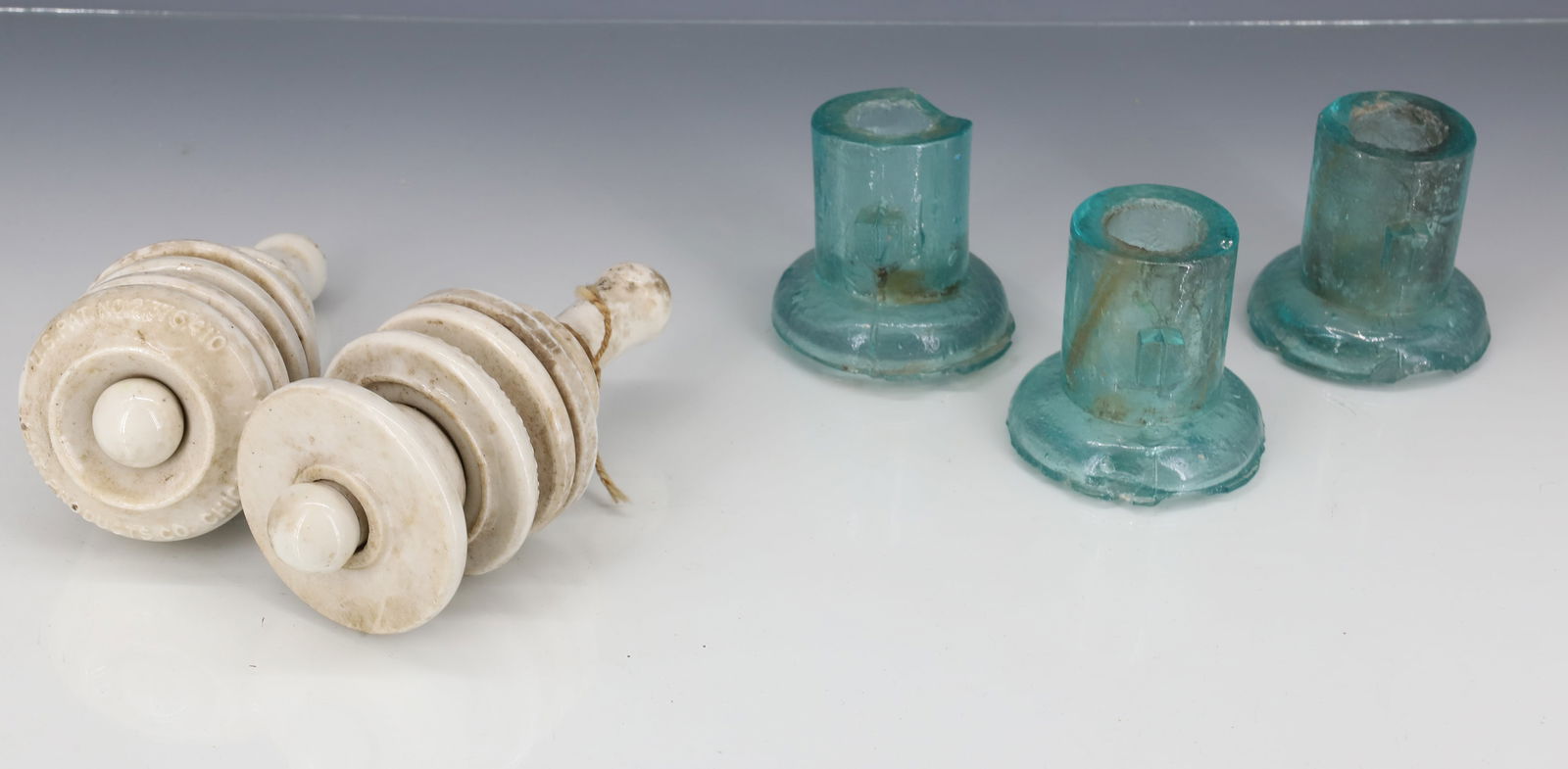 LIGHTNING ROD AND WIRE INSULATORS: (3) AQUA GLASS LIGHTNING RODS 2 1/4" X 2 3/8". (2) WHITE PORCELAIN "KENT PRODUCTS CO. CHICAGO" 5"L. PLEASE READ CAREFULLY - TEMS MUST BE PAID FOR THROUGH LIVE AUCTIONEERS OR WITH CASH OR CHECK IN PERS