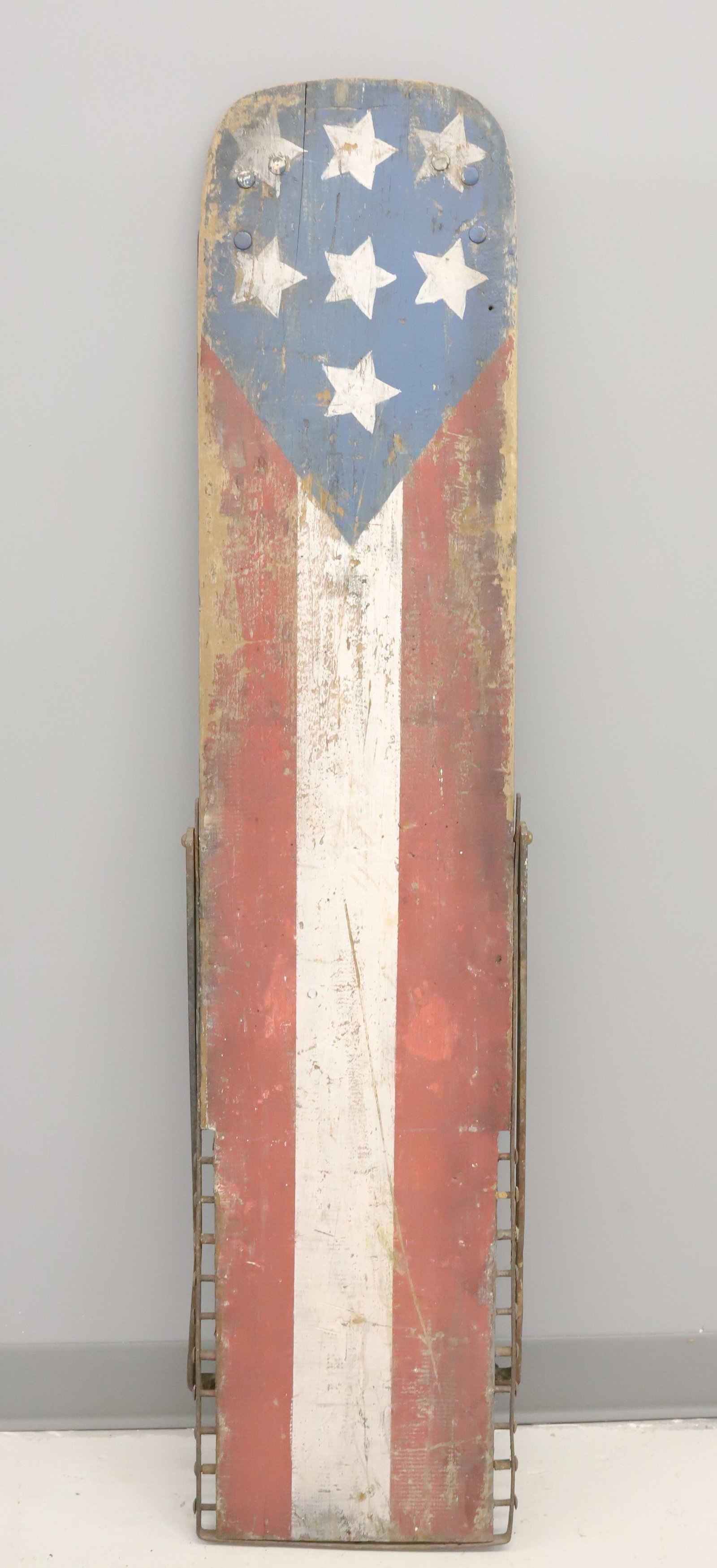 PAINT DECORATED WOOD / IRON BOARD: RED / WHITE / BLUE STARS AND STRIPES PAINTED BOARD. ADJUSTABLE IRON BASE TO PUT AT ANGLE. 54 1/2" L. PLEASE READ CAREFULLY - ITEMS MUST BE PAID FOR THROUGH LIVE AUCTIONEERS OR WITH CASH OR CHECK