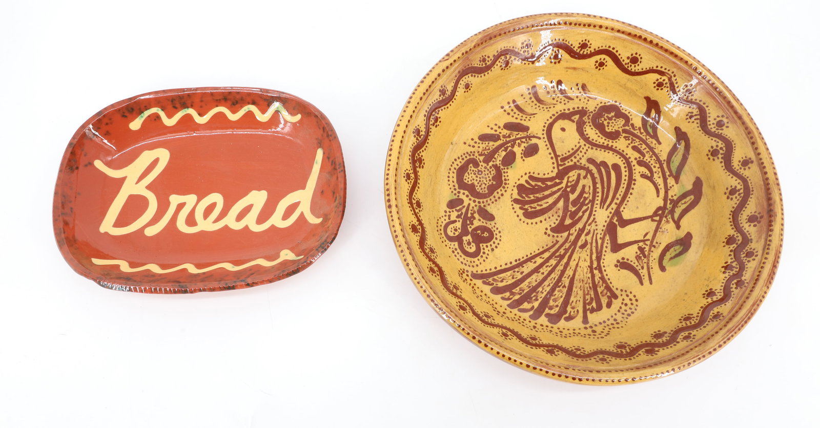 CONTEMPORARY REDWARE, FOLTZ AND JEFF WHITE: C.N. FOLTZ, REINHOLDS, PA (1976) GLAZED AND DECORATED BOWL WITH BIRD AND FLORAL. 2" X 11 1/4". WITH, SLIP DECORATED "BREAD" TRAY MRKD. JEFF WHITE, LEBANON, PA 1989 ON BOTTOM. 8 1/2" L. PLEASE