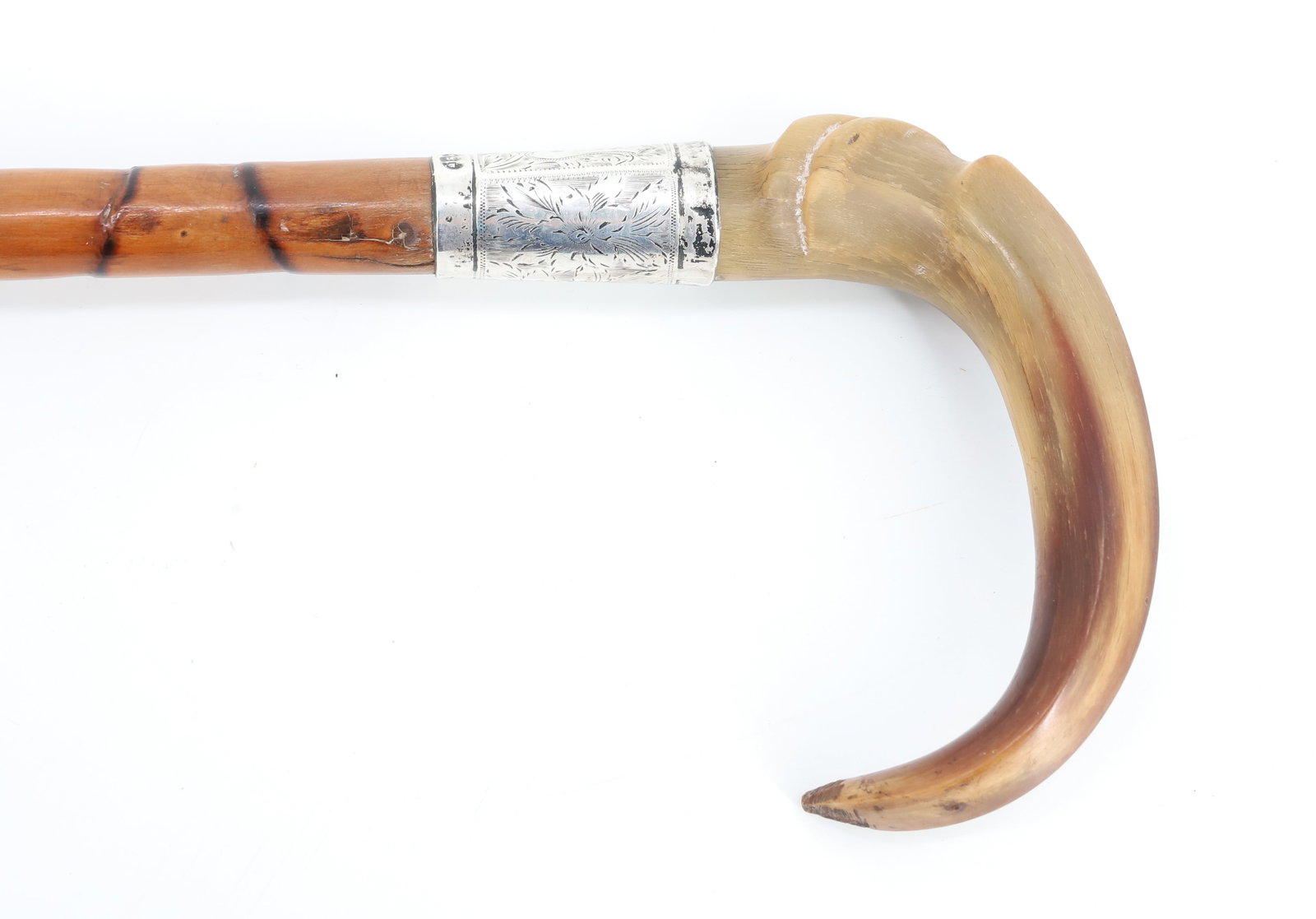 ANTIQUE BAMBOO / HORN SILVER CANE: CARVED HORN GRIP ABOVE DECORATED SILVER BAND (HALLMARKED AND MRKD. D&B). BAMBOO SHAFT. 32" L. PLEASE READ CAREFULLY - ITEMS MUST BE PAID FOR THROUGH LIVE AUCTIONEERS OR WITH CASH OR CHECK IN