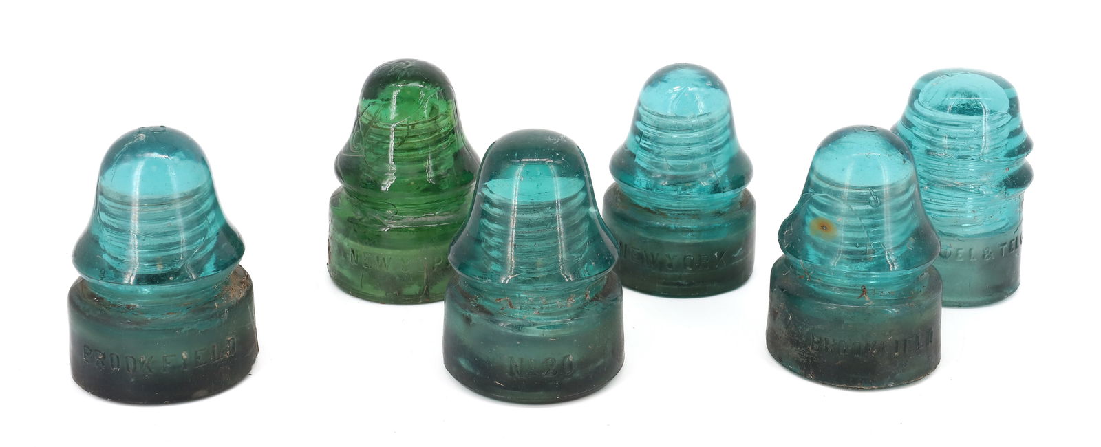 LOT OF (6) GLASS INSULATORS: INCLUDING: GREEN "BROOKFIELD, NEW YORK, "3", (3) AQUA "BROOKFIELD, NEW YORK, "5". AQUA "AM. TEL & TEL. CO." AND AQUA/GREEN "NO. 20" AVERAGE HEIGHT 3 7/8" TO 4". PLEASE READ CAREFULLY - ITEMS