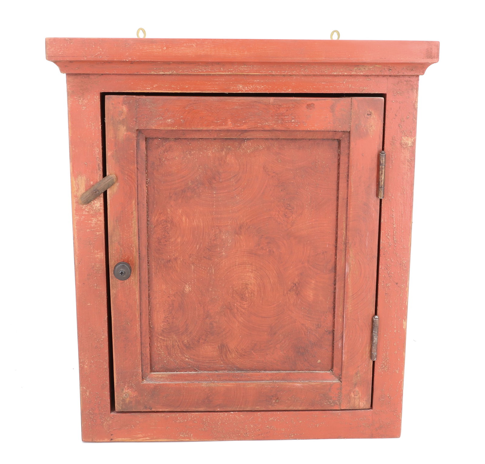 PAINT DECORATED HANGING CUPBOARD: RED PAINTED SWIRL DECORATION ON DOOR. 18 1/4" X 16 1/2" X 8 3/4". POSSIBLY CONTEMPORARY CONSTRUCTION / PAINT. PLEASE READ CAREFULLY - ITEMS MUST BE PAID FOR THROUGH LIVE AUCTIONEERS OR WITH CASH