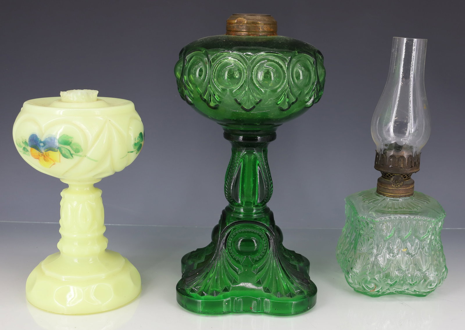 (3) VICTORIAN GLASS KEROSENE LAMPS: EMERALD GREEN BULLSEYE PATTERN LAMP, CUSTARD GLASS HEART PATTERN LAMP AND LIGHT GREEN LAMP ALL ORIGINAL 7 1/2" TO 10 1/2"H PLEASE READ CAREFULLY - ITEMS MUST BE PAID FOR THROUGH LIVE AUCTIONEERS OR WI