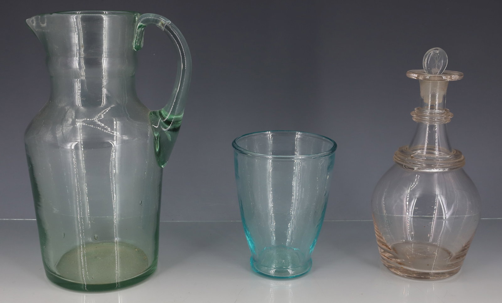 (3) 19TH C BLOWN GLASS: AQUA GREEN PITCHER WITH APPLIED HANDLE AND FAINT PONTIL, AQUA TUMBLER FAINT PONTIL, MINIATURE DECANTER WITH REEDED GRIP RING ROUGH PONTIL 8"H,4"H,6 1/4"H PLEASE READ CAREFULLY - ITEMS MUST BE PAID FOR