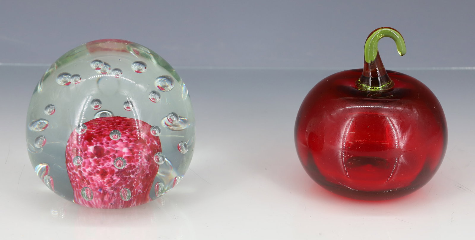 (2) GLASS PAPERWEIGHTS: BLOWN HOLLOW RED APPLE WITH GREEN STEM. CONTROLLED BUBBLES WITH CRANBERRY AND WHITE CENTER POLISHED PONTIL 3 1/2" X 3"DIA, 3 1/2" X 3 1/2" PLEASE READ CAREFULLY - ITEMS MUST BE PAID FOR THROUGH LIVE A