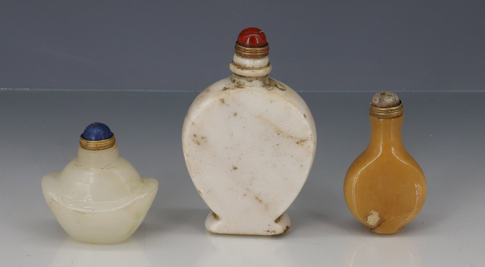 (3) CHINESE SNUFF BOTTLES: CARVED HARDSTONE WHITE , TAN AND OFF WHITE JADE METAL STOPPERS WITH CABOCHON STONE 2" TO 4" H PLEASE READ CAREFULLY - ITEMS MUST BE PAID FOR THROUGH LIVE AUCTIONEERS OR WITH CASH OR CHECK IN PERSON -