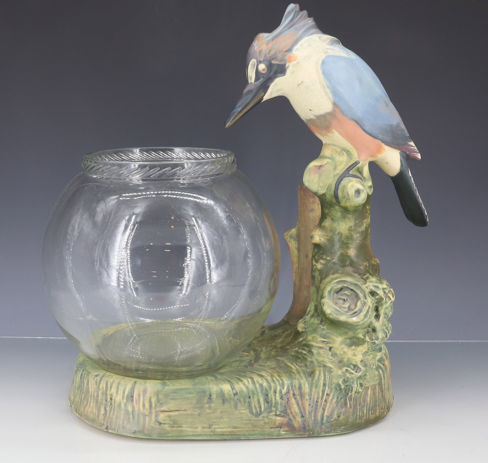 WELLER POTTERY KINGFISHER FISHBOWL STAND: POTTERY STAND WITH KINGFISHER ASIDE OF VASE. CLEAR GLASS FISH BOWL. 13 1/2" X 11 1/2". PLEASE READ CAREFULLY - ITEMS MUST BE PAID FOR THROUGH LIVE AUCTIONEERS OR WITH CASH OR CHECK IN PERSON -