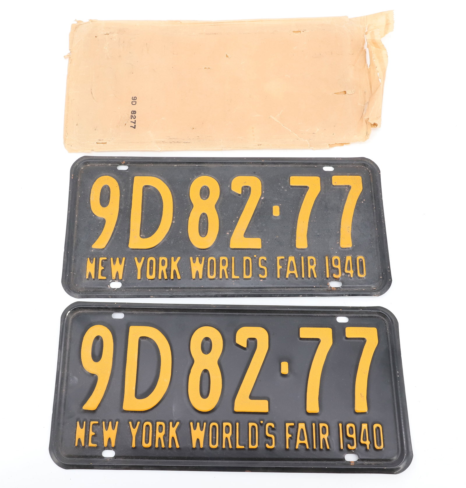 PAIR OF 1940 NY WORLD'S FAIR LICENSE PLATES: 13 1/2" L. ORIGINAL PAPER PACKAGING. PLEASE READ CAREFULLY - ITEMS MUST BE PAID FOR THROUGH LIVE AUCTIONEERS OR WITH CASH OR CHECK IN PERSON - Terms for Purchasing and Shipping of Auction Items. Pleas