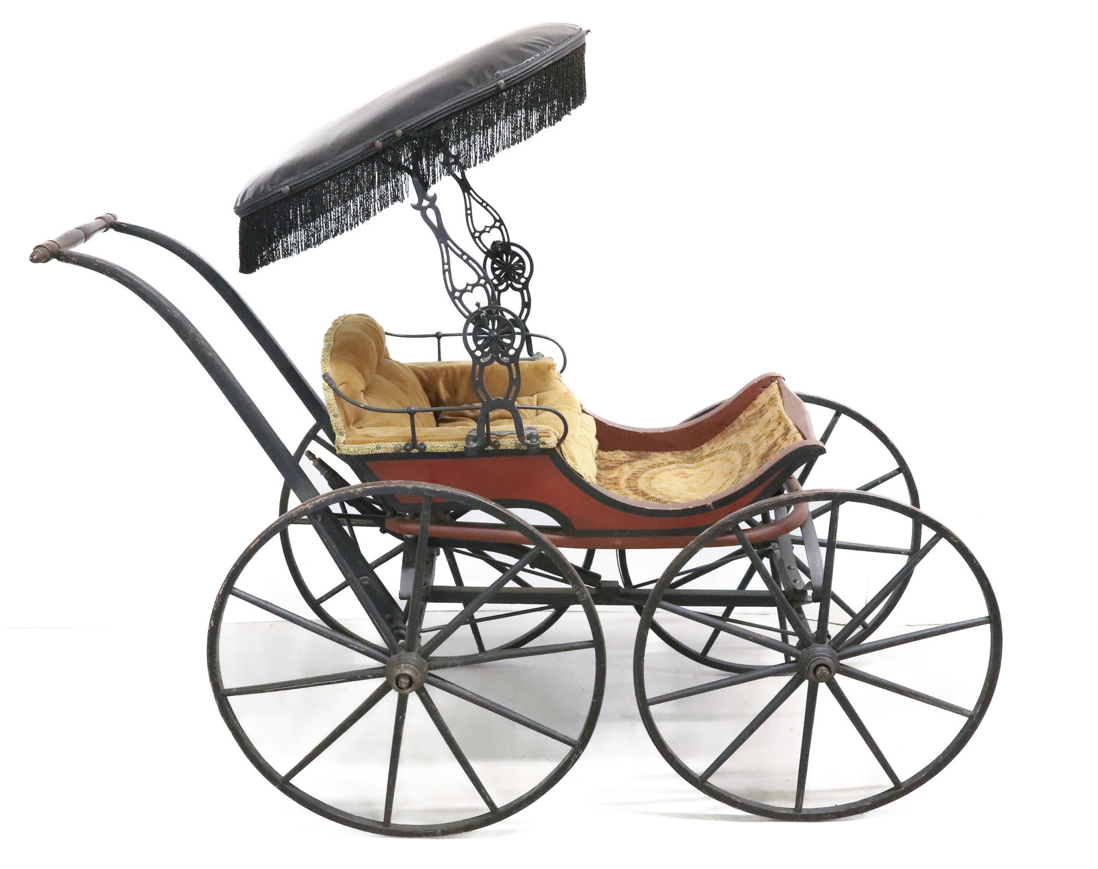 VICTORIAN DOLL / BABY CARRIAGE: PAINTED WOODEN SURFACE WITH STRIPING AND DECORATION IN RED / BLACK /YELLOW. VELVET AND CARPET INTERIOR. LEATHER TOP WITH FRINGE ON CAST IRON BRACKETS. 58" X 35" X 20 1/2". PLEASE READ CAREFULLY