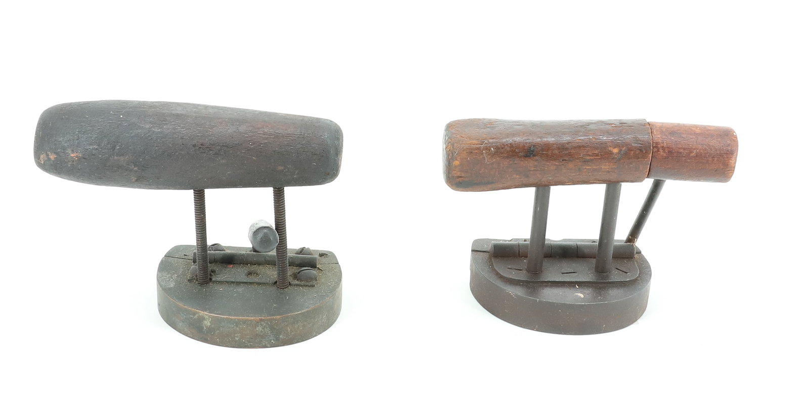 (2) SINGLE GROOVE HAT IRONS: WOODEN HANDLES. ONE WITH UNUSUAL TENSION LATCH. 3" LENGTH. PLEASE READ CAREFULLY - ITEMS MUST BE PAID FOR THROUGH LIVE AUCTIONEERS OR WITH CASH OR CHECK IN PERSON - Terms for Purchasing and Shipping