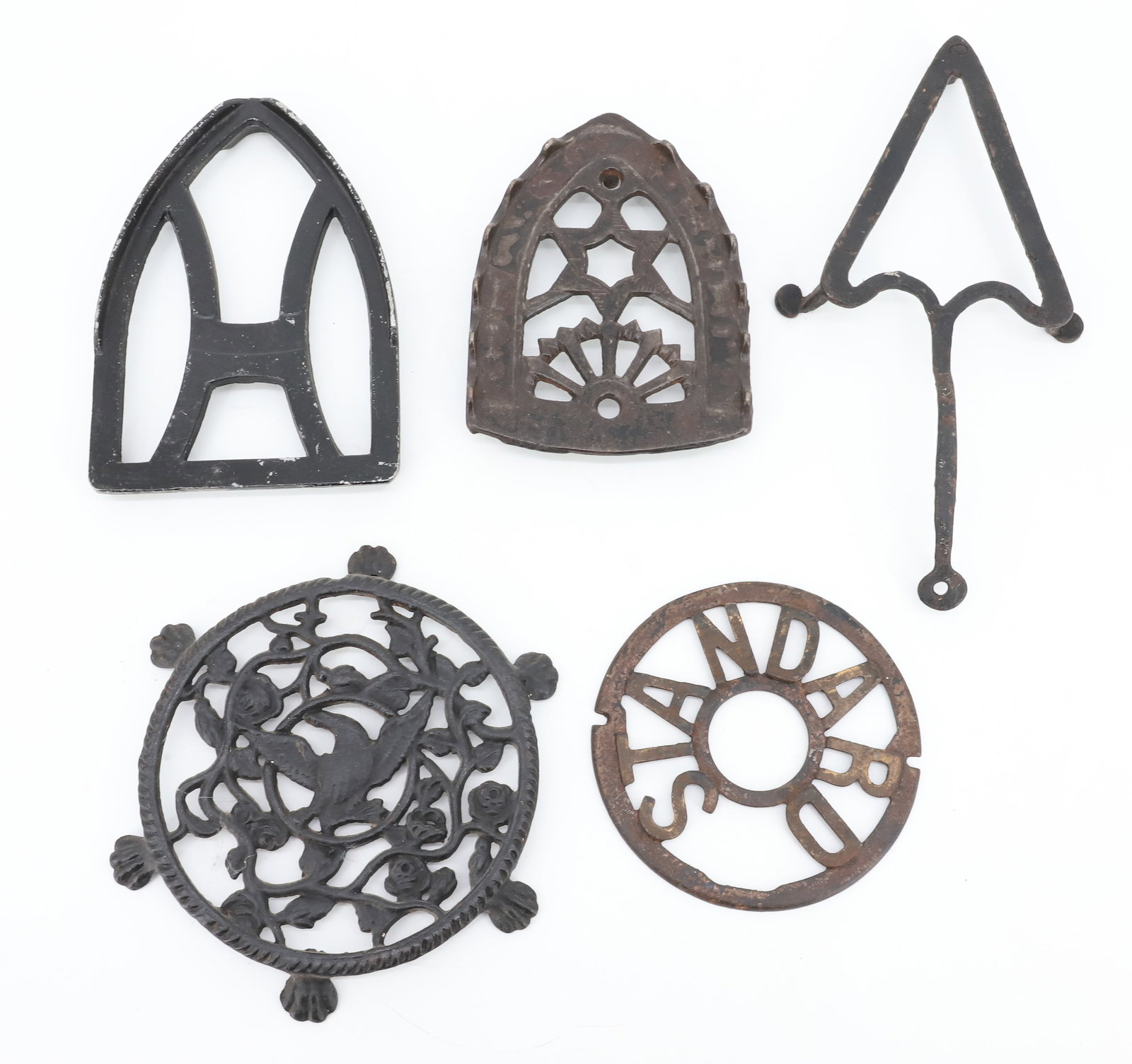 LOT OF ANTIQUE PRESSING IRON TRIVETS: (5) INCLUDING: STAR OVER ARCH, HANDWROUGHT HEART WITH FEET, "H" TRIVET, CIRCULAR "STANDARD" AND SIX-FOOTED CIRCULAR TRIVET W/ EAGLE. PLEASE READ CAREFULLY - ITEMS MUST BE PAID FOR THROUGH LIVE