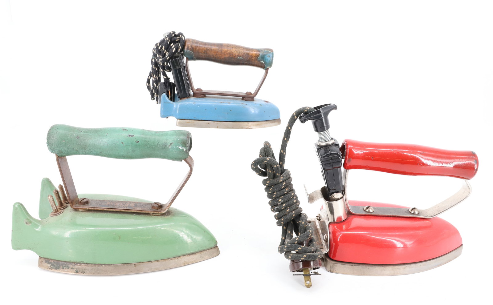 (3) ENAMEL ELECTRIC IRONS: WAAGE THREE HEAT IN GREEN. RED ENAMEL BLUE LINE, MONTGOMERY WARD. WAAG TRAVELER'S IRON IN BLUE. PLEASE READ CAREFULLY - ITEMS MUST BE PAID FOR THROUGH LIVE AUCTIONEERS OR WITH CASH OR CHECK IN PERSON