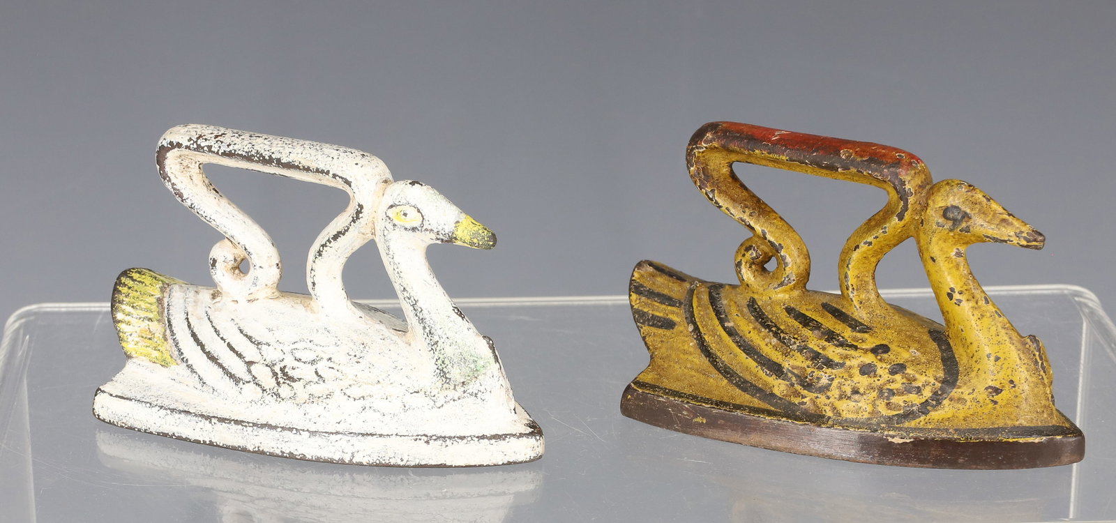(2) PAINTED MINIATURE SWAN IRONS: YELLOW / BLACK / RED AND WHITE / YELLOW. 2 3/4" L. PLEASE READ CAREFULLY - ITEMS MUST BE PAID FOR THROUGH LIVE AUCTIONEERS OR WITH CASH OR CHECK IN PERSON - Terms for Purchasing and Shipping of