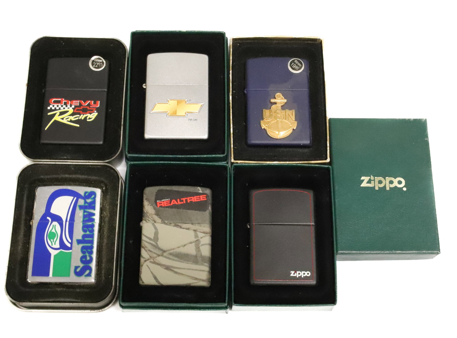 (6) Zippo Lighters, New in Boxes: Advertising, USN, Seahawks and More. PLEASE READ CAREFULLY - ITEMS MUST BE PAID FOR THROUGH LIVE AUCTIONEERS OR WITH CASH OR CHECK IN PERSON - Terms for Purchasing and Shipping of Auction Items. Pleas