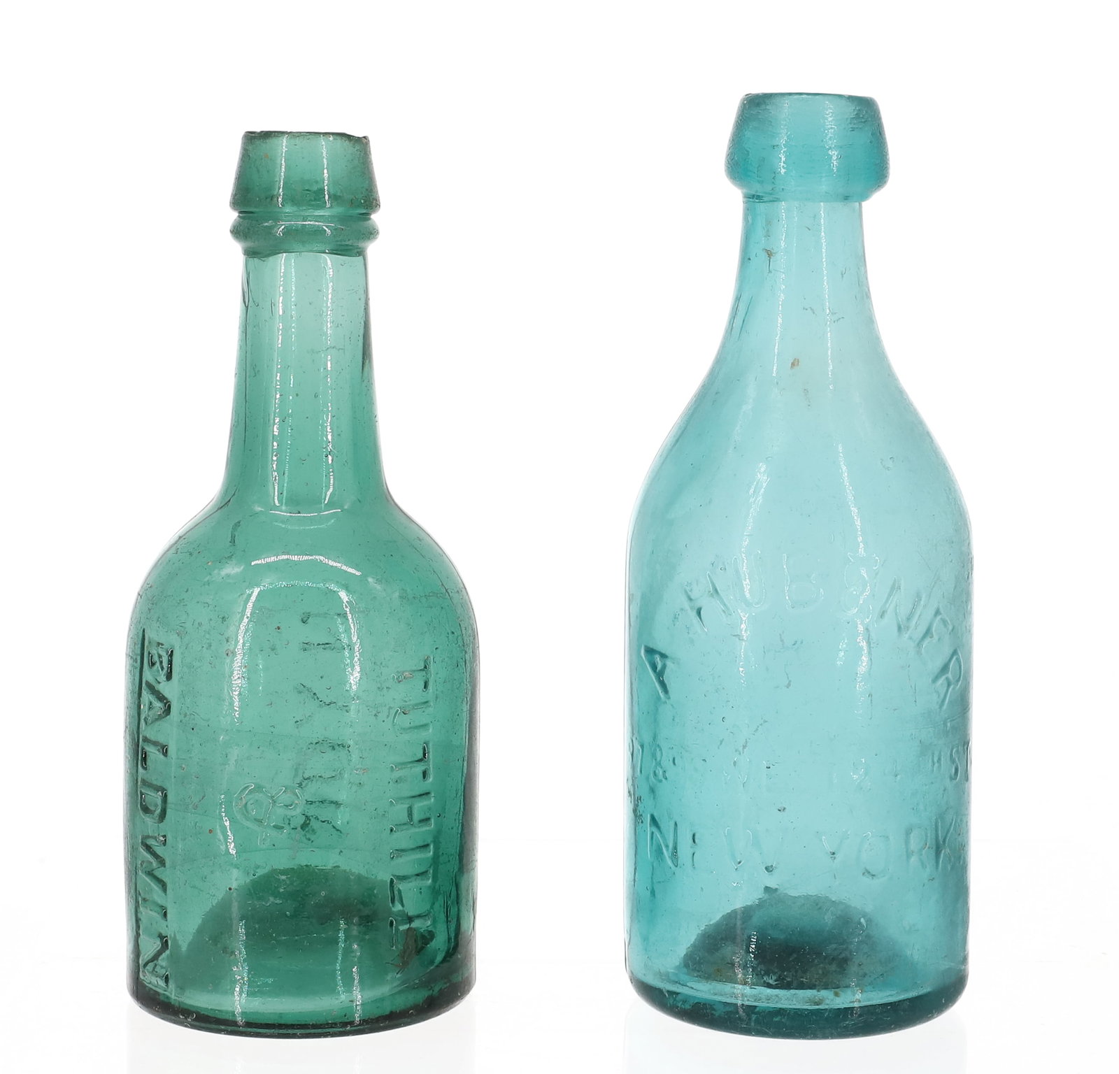 (2) 19TH C. NEW YORK BOTTLES: INCLUDING: GREEN "TUTHILL & BALDWIN, N. YORK" 6 3/4" H. WITH, "A. HUBENER 97 & 99 WEST 24TH ST. NEW YORK, MINERAL WATER" 7" H. PLEASE READ CAREFULLY - ITEMS MUST BE PAID FOR THROUGH LIVE AUCTIONEERS