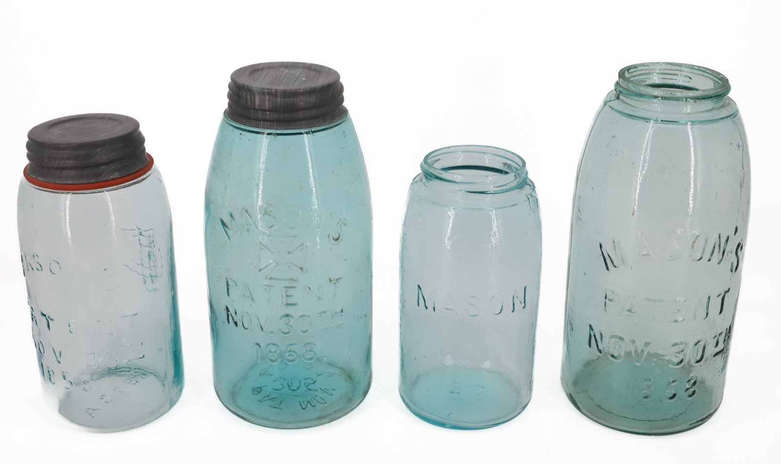 (4) MASON'S FRUIT JARS: INCLUDING: "MASON'S PATENT NOV 30TH 1858" (MONOGRAM ON BACK, A226 BOTTOM) 7 1/4" H. "MASON" JAR WITH KEYSTONE IN CIRCLE (54 ON BOTTOM) 7" H. "MASON'S PATENT NOV. 30TH 1858" (EMBOSSED IRON CROSS)