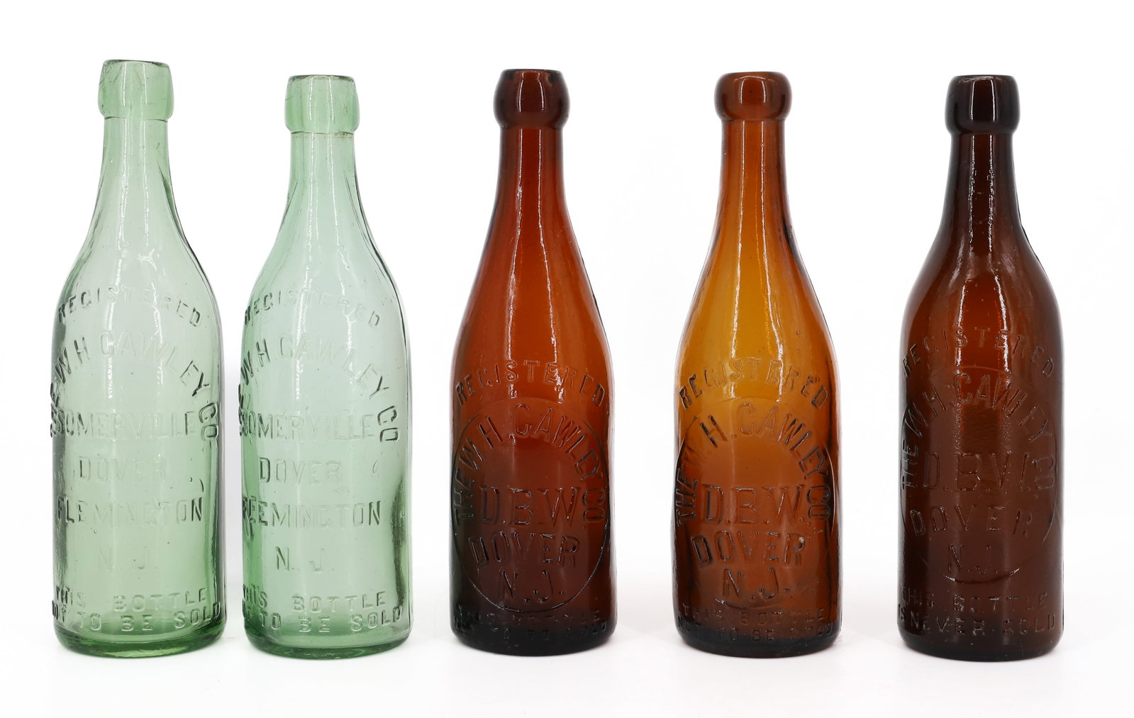 (5) DOVER, NJ BOTTLES: THREE EMBOSSED AMBER: THE W.H. CAWLEY CO. WITH, TWO LIGHT GREEN "THE W.H. CAWLEY, SOMERVILLE, DOVER, FLEMINGTON" 9" H. PLEASE READ CAREFULLY - ITEMS MUST BE PAID FOR THROUGH LIVE AUCTIONEERS OR WITH