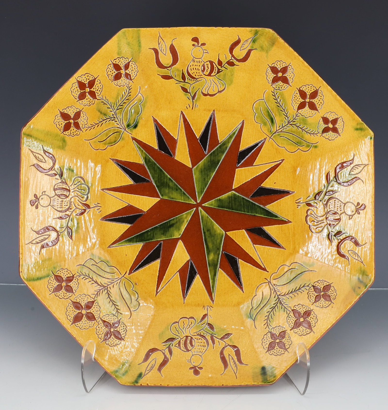 BREININGER POTTERY DECORATED PIE PLATE: OCTAGONAL DESIGN, WITH COMPASS IN CENTER, MULTI COLOR GLAZE, FLORAL AND BIRD BORDER, MARKED AND DATED ON BACK 1991, 14" D PLEASE READ CAREFULLY - ITEMS MUST BE PAID FOR THROUGH LIVE AUCTIONEERS OR