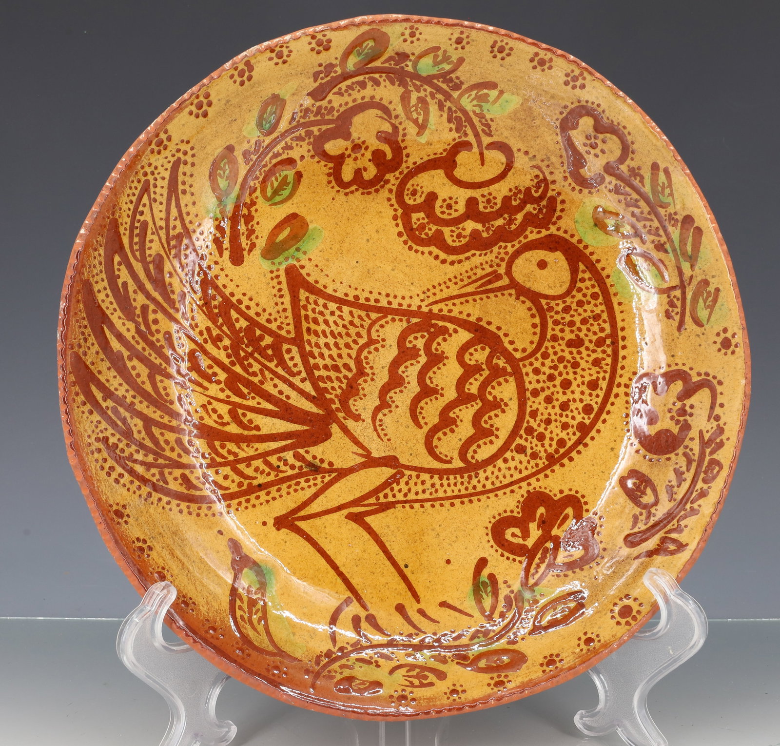 FULTZ REDWARE PIE PLATE: LARGE BIRD DESIGN, SURROUNDED BY FLOWERS, YELLOW AND GREEN GLAZE, DATED 1976 - 10 3/8" PLEASE READ CAREFULLY - ITEMS MUST BE PAID FOR THROUGH LIVE AUCTIONEERS OR WITH CASH OR CHECK IN PERSON - Terms