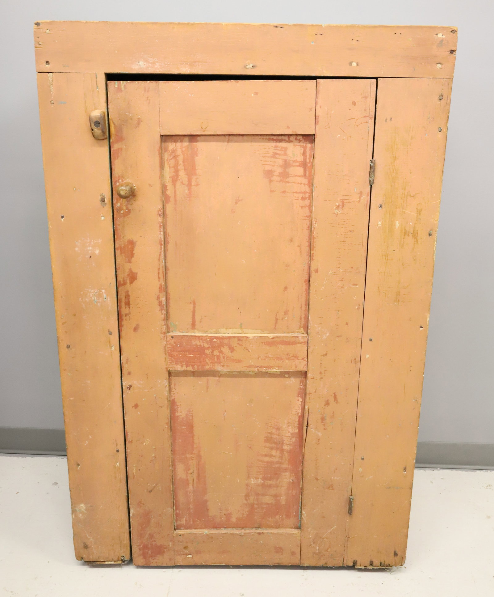 EARLY ONE DOOR PAINTED CUPBOARD: PALE SALMON PAINTED SURFACE, UNUSUAL GREEN PAINTED GALLEY TOP, 3 INTERIOR SHELVES - 51 1/2" X 33 1/2" X 16" PLEASE READ CAREFULLY - ITEMS MUST BE PAID FOR THROUGH LIVE AUCTIONEERS OR WITH CASH OR