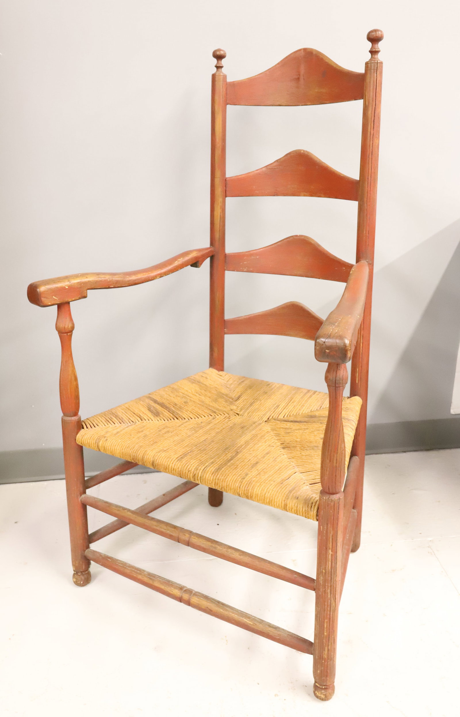 18TH CENTURY LADDER BACK CHAIR: RED PAINTED SURFACE WITH RUSH SEAT, 45" X 25 1/2" X 17" PLEASE READ CAREFULLY - ITEMS MUST BE PAID FOR THROUGH LIVE AUCTIONEERS OR WITH CASH OR CHECK IN PERSON - Terms for Purchasing and Shipping of
