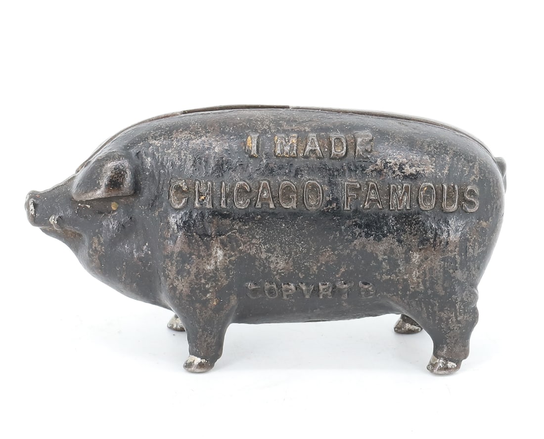 1902 CAST IRON PIG BANK: I MADE CHICAGO FAMOUS, 1902 PAINTED STILL BANK. 4" L. PLEASE READ CAREFULLY - ITEMS MUST BE PAID FOR THROUGH LIVE AUCTIONEERS OR WITH CASH OR CHECK IN PERSON - Terms for Purchasing and Shipping of Auc