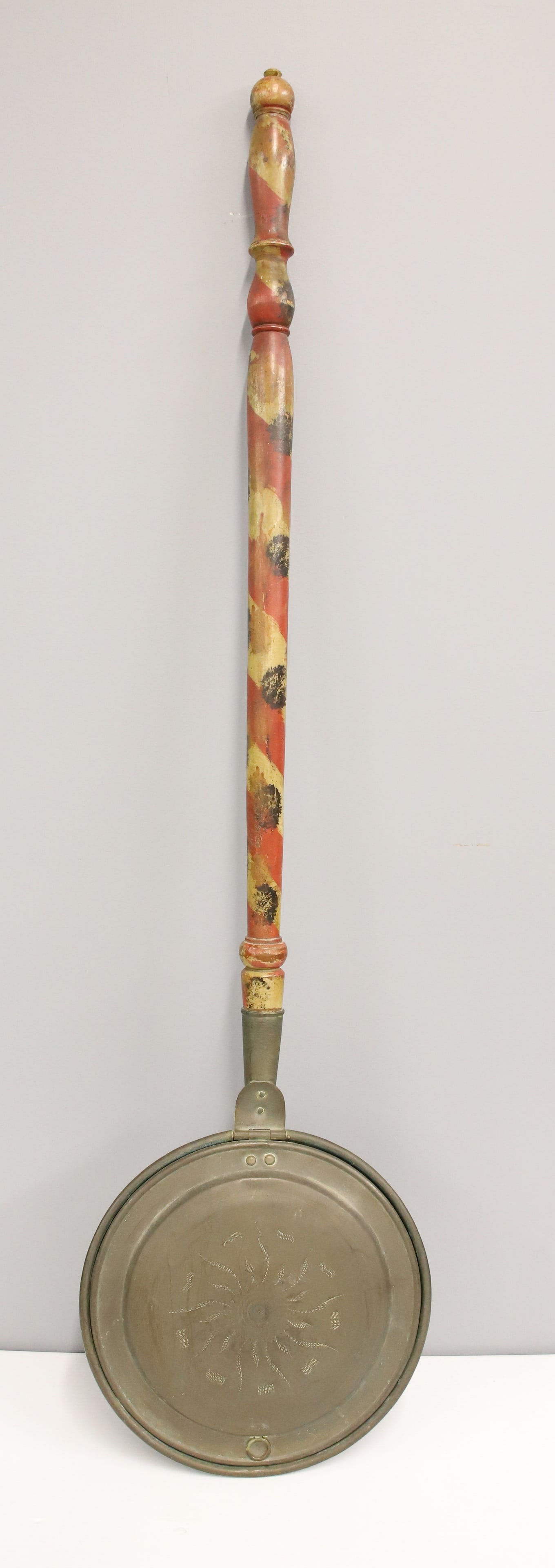 PAINT DECORATED WOOD AND BRASS BED WARMER: RED, YELLOW, AND BLACK DECORATED HANDLE - DECORATED BRASS LID - 45 1/2" X 11 3/4" PLEASE READ CAREFULLY - ITEMS MUST BE PAID FOR THROUGH LIVE AUCTIONEERS OR WITH CASH OR CHECK IN PERSON - Terms for