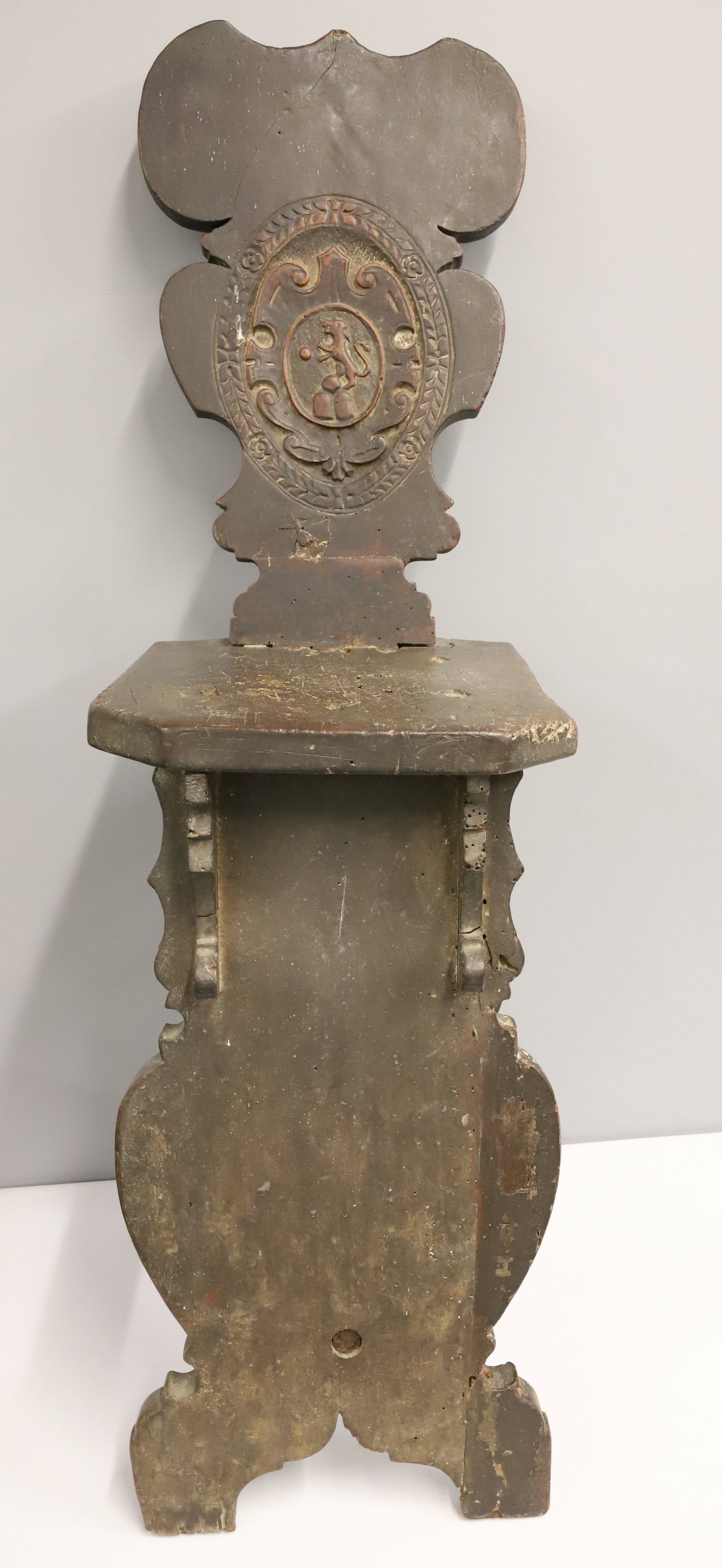 ITALIAN RENAISSANCE CARVED HALL CHAIR: DECORATED CHAIR BACK WITH ANIMAL / SHIELD IN OVAL. MORTISED AND EARLY NAIL CONSTRUCTION. 38 1/2" X 11 1/4" X 17". PLEASE READ CAREFULLY - ITEMS MUST BE PAID FOR THROUGH LIVE AUCTIONEERS OR WITH CASH