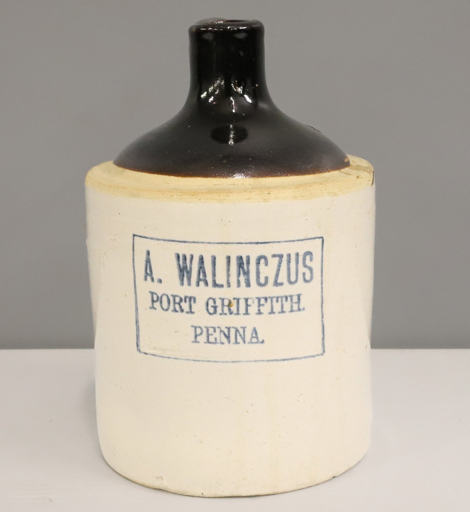 PORT GRIFFITH, PA STONEWARE ADVERTISING JUG: A. WALINCZUS, PORT GRIFFITH, PENNA. 9" H. PLEASE READ CAREFULLY - ITEMS MUST BE PAID FOR THROUGH LIVE AUCTIONEERS OR WITH CASH OR CHECK IN PERSON - Terms for Purchasing and Shipping of Auction Items.