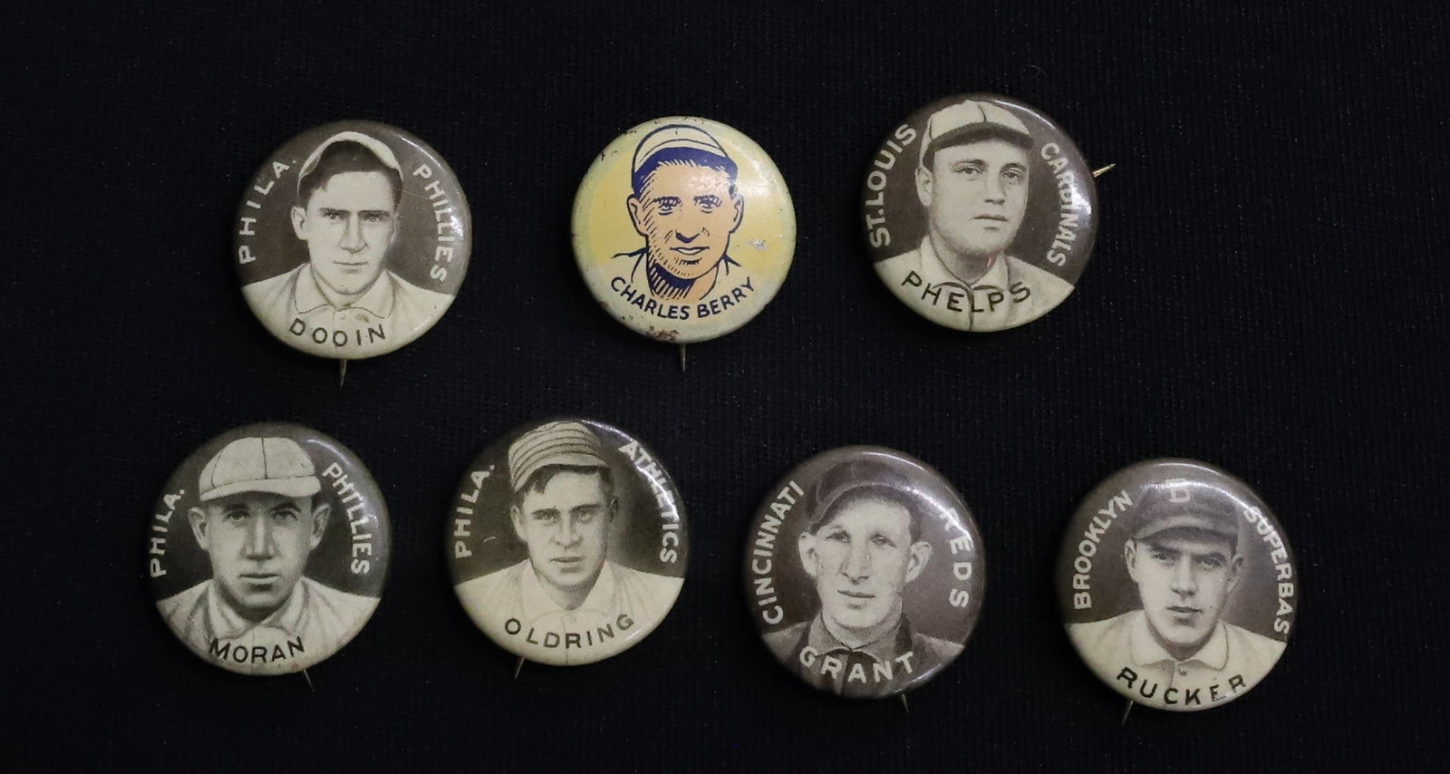 LOT OF SWEET CAPORAL BASEBALL PLAYER PINS: (6) PINS BY SWEET CAPORAL CIGARETTES (GRANT, PHELPS, RUCKER, MORAN, DOOIN AND OLDRING) . PLUS (1) 1930 CRACKER JACK PIN OF CHARLES BERRY. PLEASE READ CAREFULLY - ITEMS MUST BE PAID FOR THROUGH LIVE AU