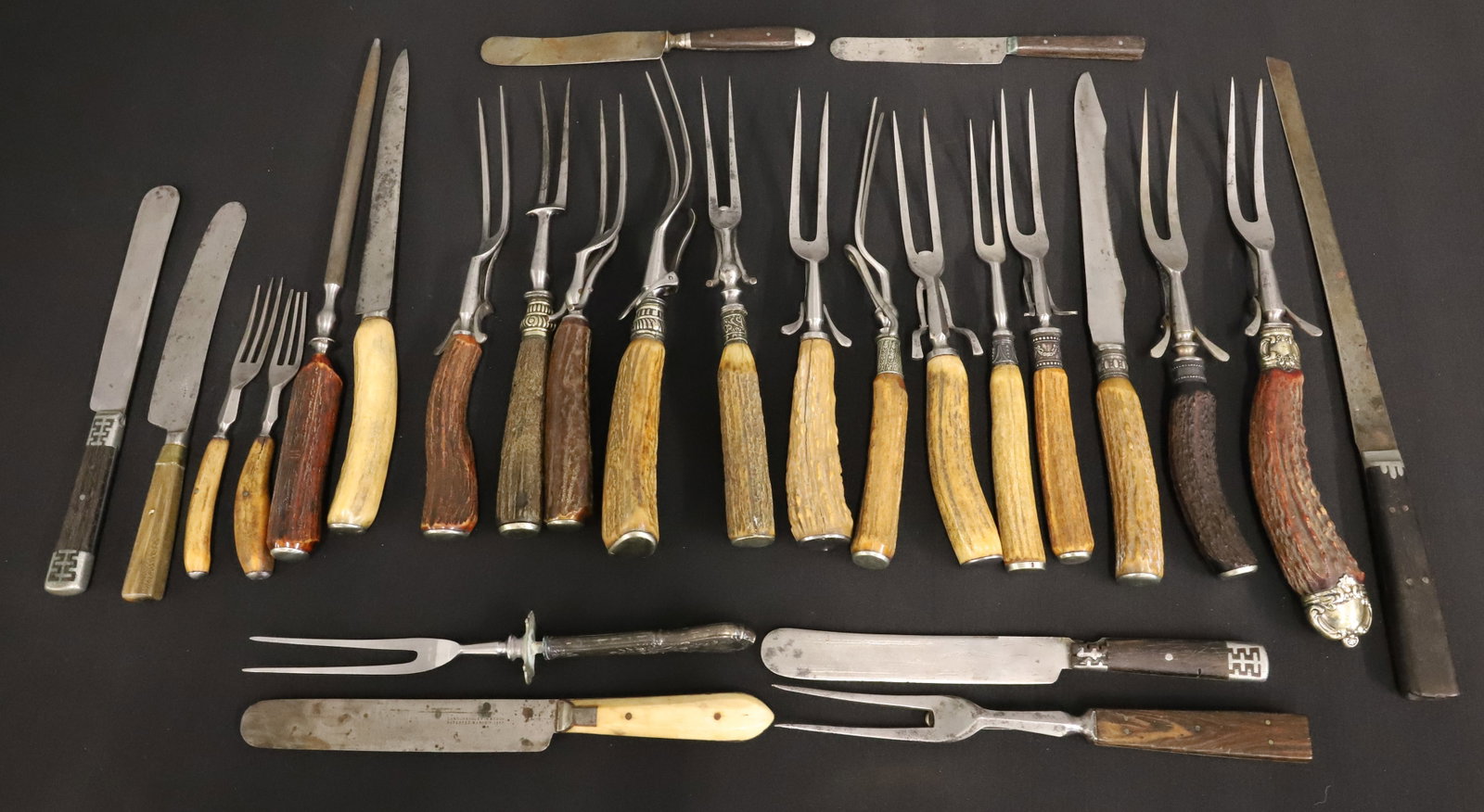 LOT OF ANTLER HANDLE CARVING SETS: TWO-PRONG SERVING FORKS, CARVING KNIVES AND SHARPENER. PLUS, ASSORTMENT OF OTHER TYPES OF KNIVES/FORKS. THREE MRKD. STERLING ON BANDING. PLEASE READ CAREFULLY - ITEMS MUST BE PAID FOR THROUGH LIVE