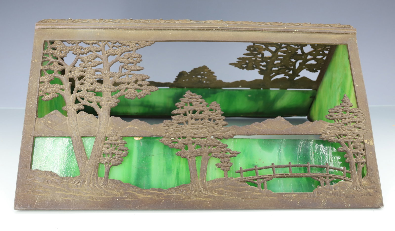 ARTS & CRAFT SLAG GLASS LAMP SHADE: CAST TREES, MOUNTAINS AND BRIDGE. GREEN SLAG GLASS PANELS. 6 1/4" X 13 7/8" X 11". PLEASE READ CAREFULLY - ITEMS MUST BE PAID FOR THROUGH LIVE AUCTIONEERS OR WITH CASH OR CHECK IN PERSON - Terms for