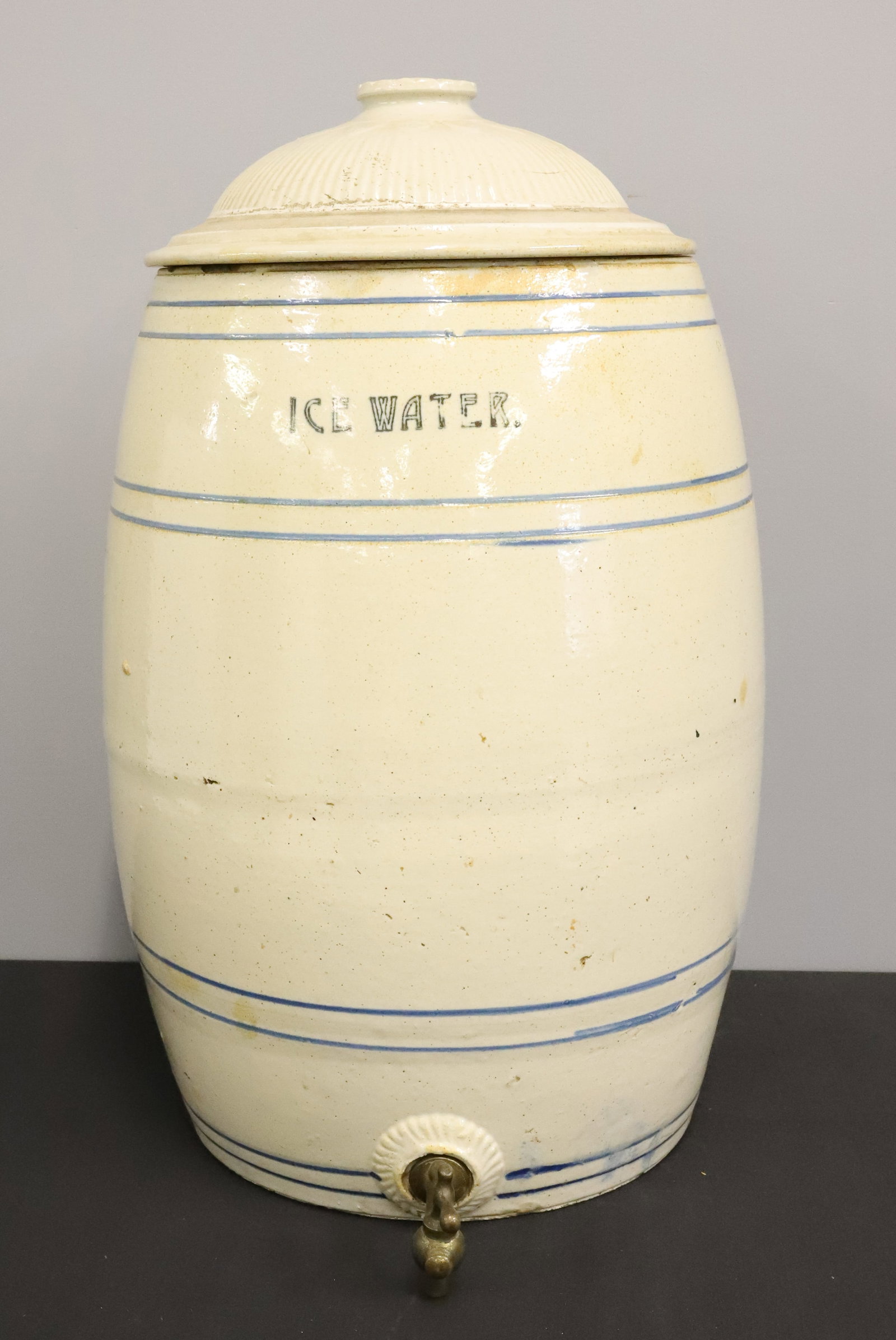 STONEWARE "ICE WATER" COOLER: BLUE BANDING. MRKD "8" ON BACK. METAL SPIGOT. RIBBED LID. TOTAL HEIGHT 22". PLEASE READ CAREFULLY - ITEMS MUST BE PAID FOR THROUGH LIVE AUCTIONEERS OR WITH CASH OR CHECK IN PERSON - Terms for