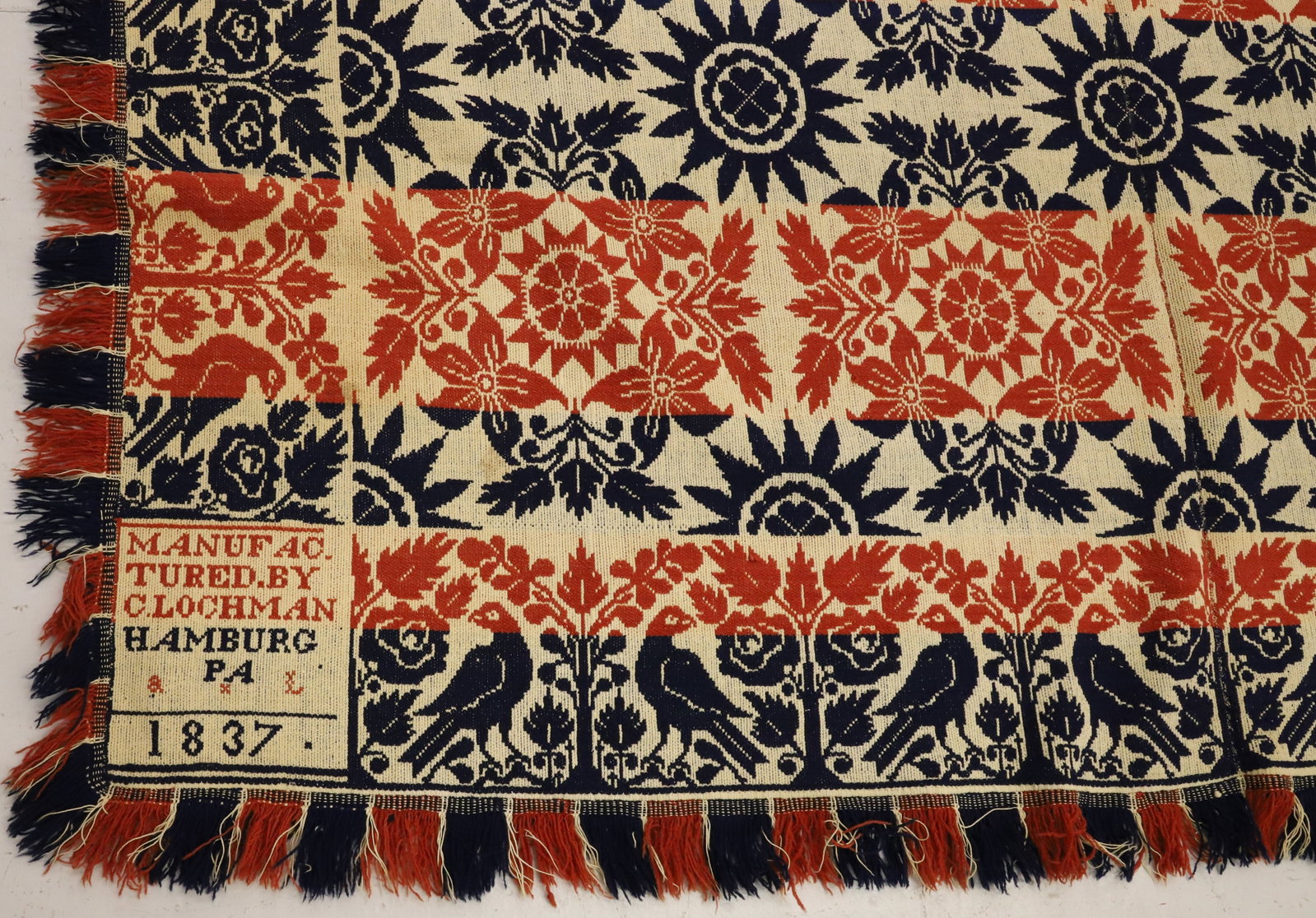 19TH C. HAMBURG, PA COVERLET: RED / WHITE / BLUE COLORS. TWO-PIECE COVERLET. MRKD. IN TWO CORNERS " MANUFACTURED BY CLOCHMAN, HAMBURG, PA 1837" LEAF, FLORAL, COMPASS STAR WITH BIRD BORDER. FRINGE EDGE. 92" X 78". PLEASE READ CAREF