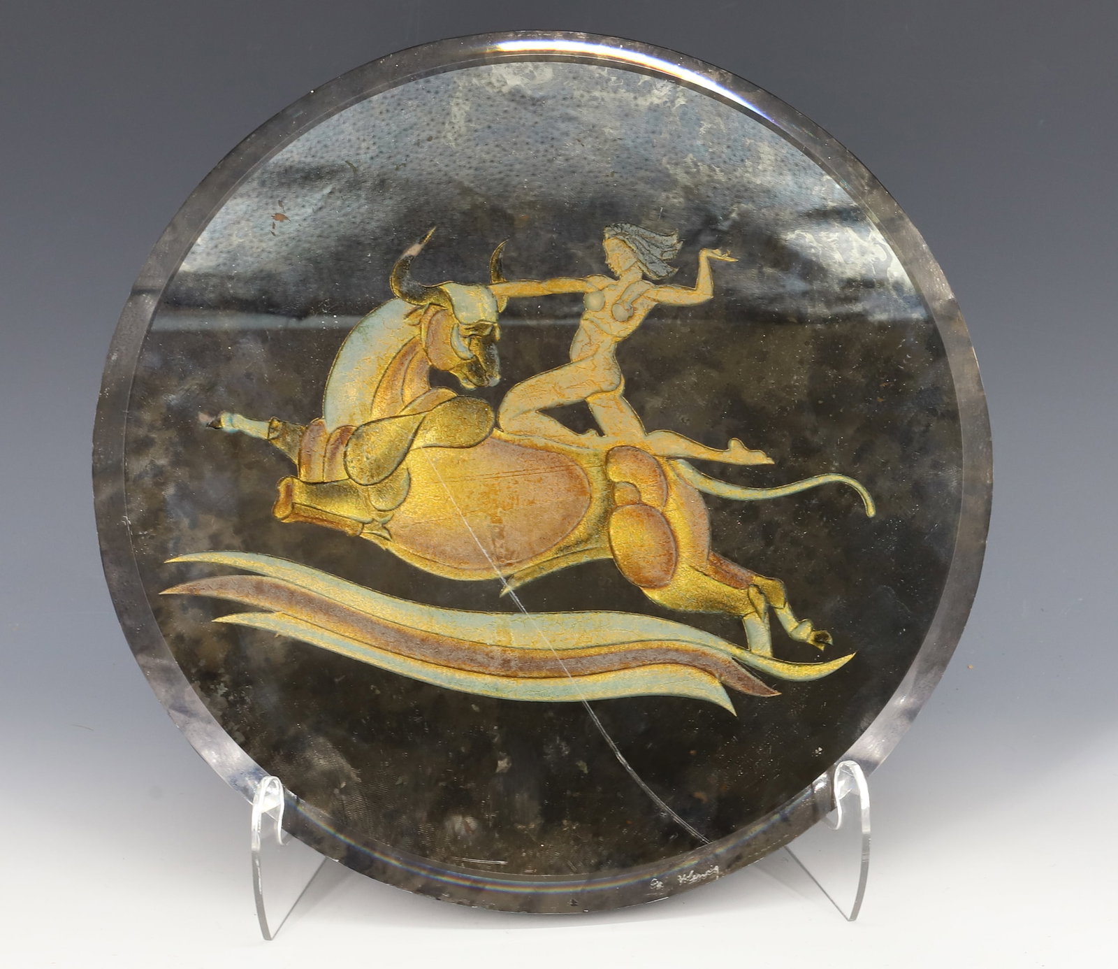 ART DECO ERA WALL PLAQUE: MIRRORED WALL PLAQUE WITH WOMAN KNEELING ON BACK OF BULL. DARK MIRROR SURFACE WITH SHADES OF GOLD AND BROWN. BEVELED EDGE. 12" D. PLEASE READ CAREFULLY - ITEMS MUST BE PAID FOR THROUGH LIVE