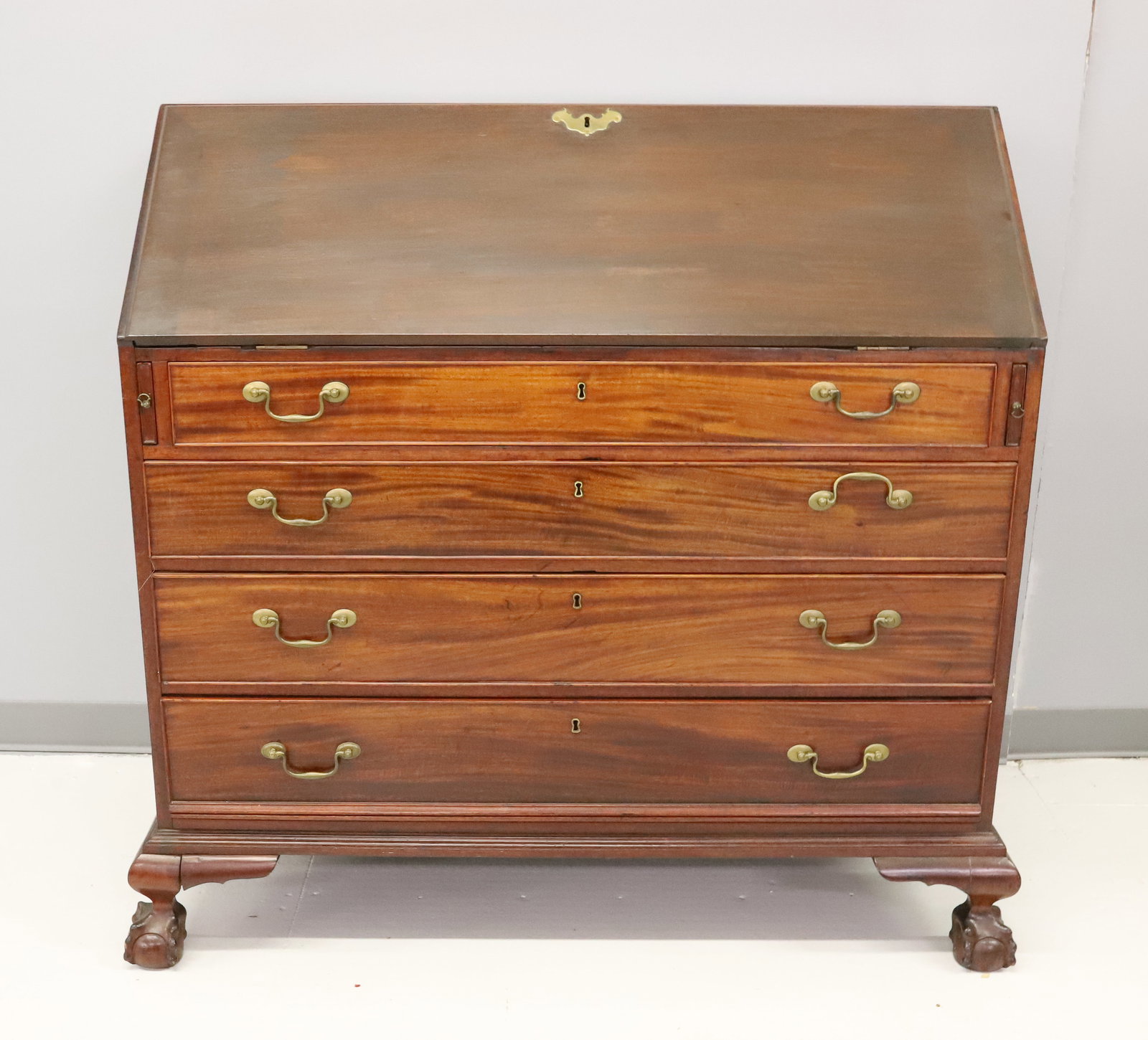 EARLY MAHOGANY SLANT-FRONT DESK: 18TH / 19TH C. DROP-FRONT DESK WITH INTERIOR DRAWERS OVER FOUR GRADUATED DRAWERS. BRASS HARDWARE. BALL AND CLAW FEET. 45 1/4" X 43 3/4" X 24". PLEASE READ CAREFULLY - ITEMS MUST BE PAID FOR THROUGH