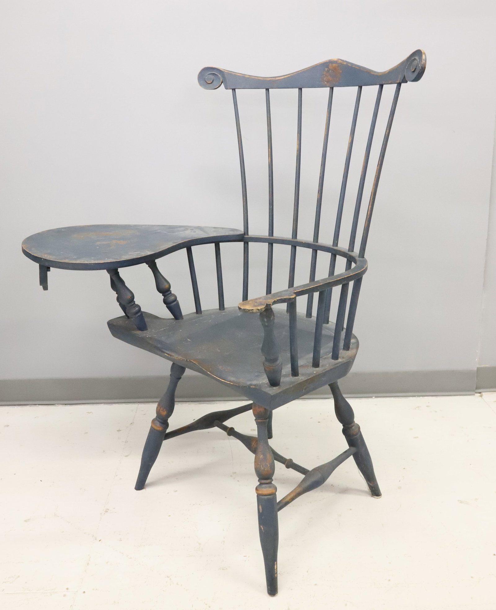 PAINTED WINDSOR ARMCHAIR W/ WRITING SURFACE: REPRODUCTION CHAIR IN COUNTRY BLUE PAINT. PEGGED / MORTISE CONSTRUCTION. TURNED LEGS. 44 3/4" X 35" X 17" . PLEASE READ CAREFULLY - ITEMS MUST BE PAID FOR THROUGH LIVE AUCTIONEERS OR WITH CASH OR