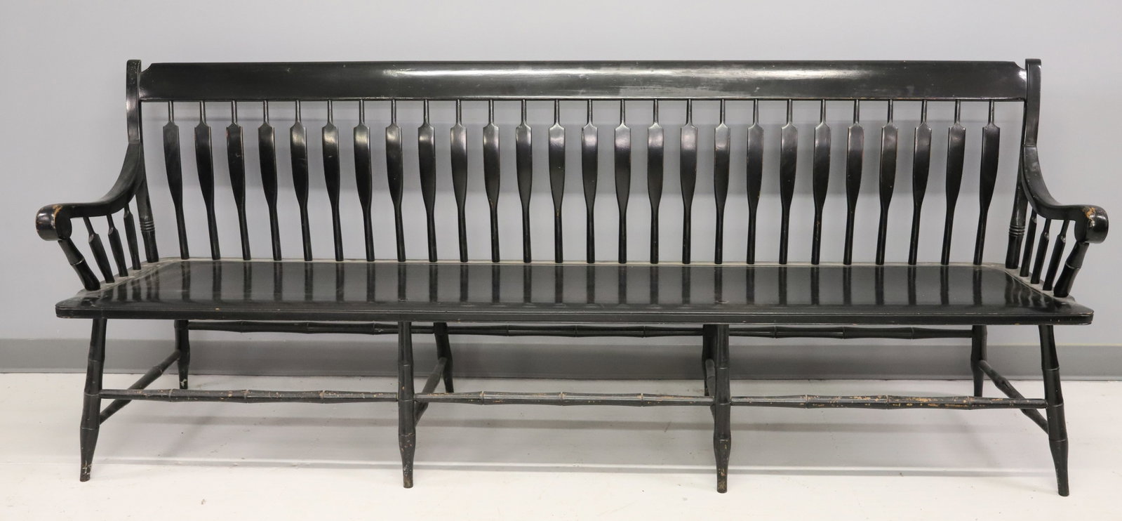PAINTED DEACON'S HALL BENCH: BLACK PAINTED SURFACE WITH ARROW BACK. LEGS MORTISED THROUGH SEAT. 33 3/4" X 83" X 19". PLEASE READ CAREFULLY - ITEMS MUST BE PAID FOR THROUGH LIVE AUCTIONEERS OR WITH CASH OR CHECK IN PERSON - Terms