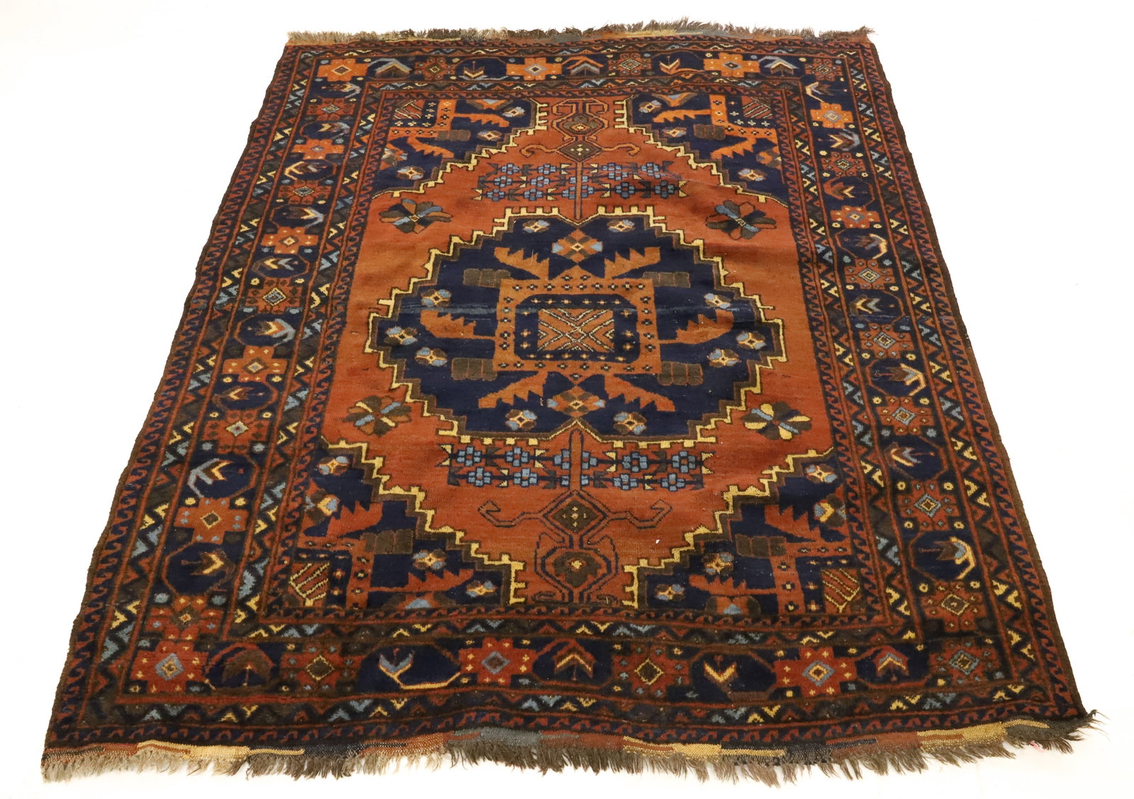 ANTIQUE ORIENTAL RUG: RUST/ORANGE AND NAVY BLUE WITH BROWN AND CREAM. FLORAL AND GEOMETRIC PATTERNS. 73" X 62". PLEASE READ CAREFULLY - ITEMS MUST BE PAID FOR THROUGH LIVE AUCTIONEERS OR WITH CASH OR CHECK IN PERSON -