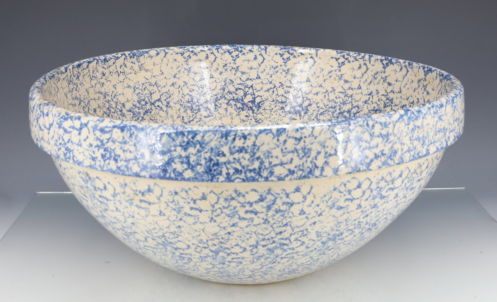LARGE SPONGEWARE MIXING BOWL: BLUE SPONGING ON CREAM BODY. STAMPED ON BOTTOM "R.R.P. CO. ROSEVILLE, OHIO" 7" X 15 1/2".