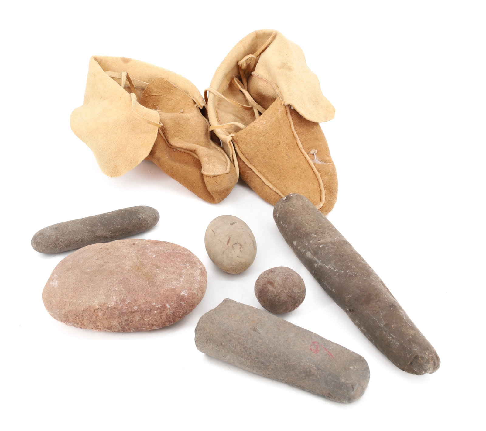 LOT OF STONE ARTIFACTS / MOCCASINS: (6) TRADITIONAL STONE TOOLS /IMPLEMENTS. LARGEST 11 1/4" L. WITH, PAIR OF PLAIN STYLE MOCCASINS.