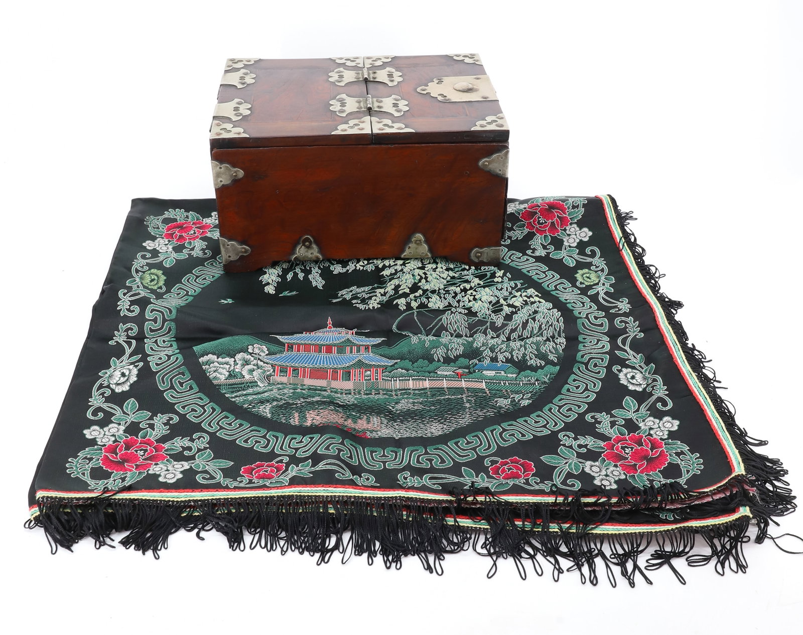 ASIAN VANITY BOX AND TABLE COVER: DARK WOOD WITH METAL ACCENTS. LID LIFTS TO REVEAL MIRROR OVER SINGLE DRAWER. 5 1/2" X 10 1/4" X 7 1/2". WITH, CHINESE SILK TABLE COVER WITH FOUR QUADRANTS WITH PAGODA. FLORAL BORDERS. FRINGE EDGE.