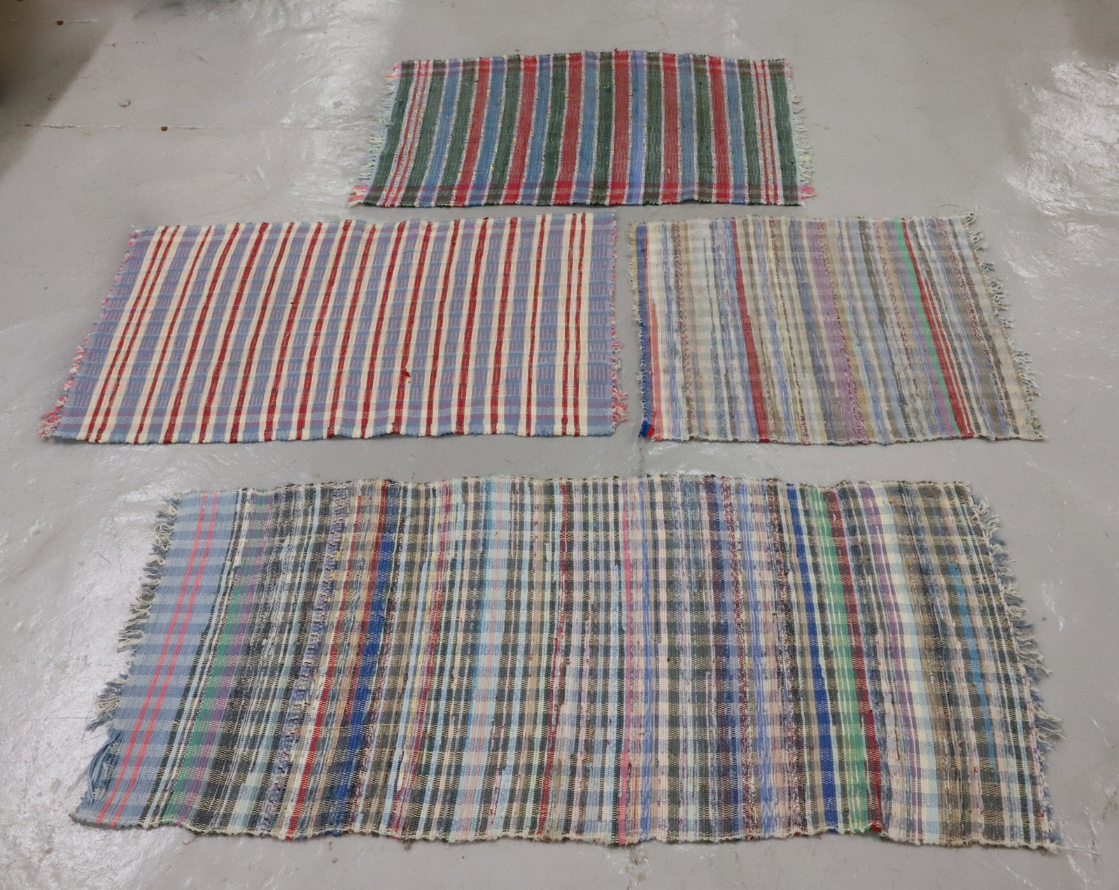 (4) RAG RUGS: VARIOUS COLORS AND SIZES. LARGEST 65 1/2" X 29 1/2".