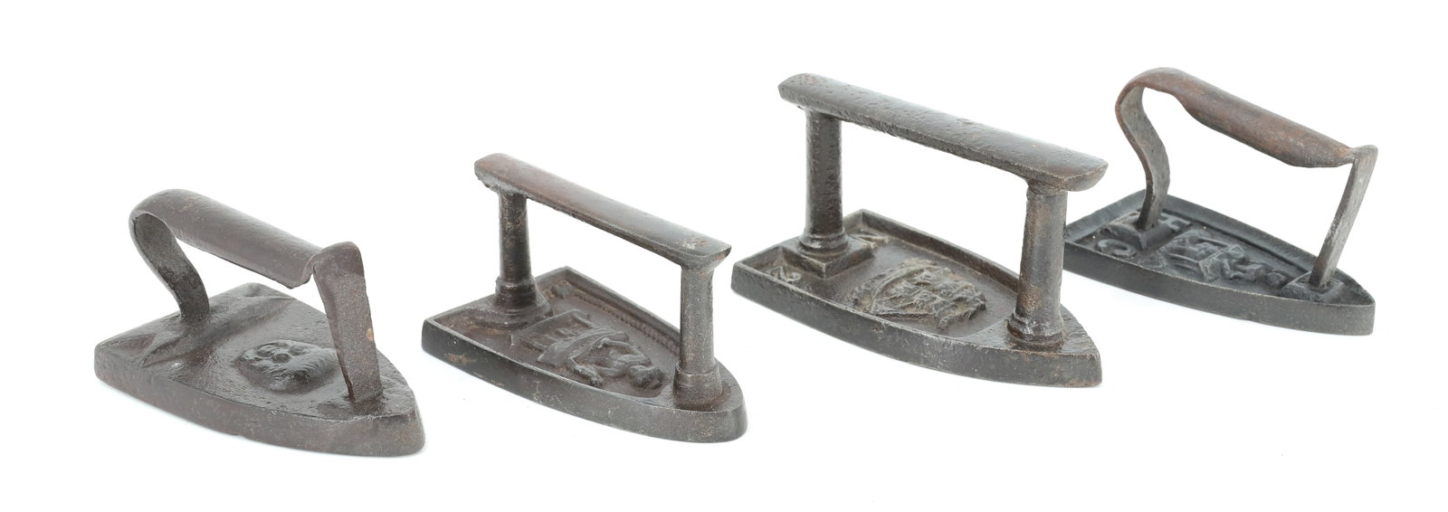 (4) EARLY FLAT IRONS: SMALL SIZE INCLUDING: EMBOSSED FLAT IRON WITH LADY IRONING (H.C. INITIALS). #2 EMBOSSED IRON WITH SAILING SHIP. EMBOSSED IRON WITH WOMAN IRONING. SMALLEST HAS MAN'S FACE (OR BACCHUS). 4" TO 4 1/2" LEN