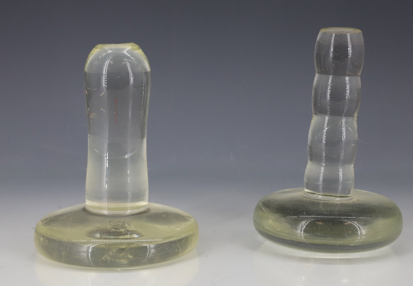 (2) POLISHING IRONS: CLEAR GLASS WITH ROUND, SMOOTH BOTTOMS. 3 1/2" AND 3 3/4" DIAMETERS. PLEASE READ CAREFULLY - ITEMS MUST BE PAID FOR THROUGH LIVE AUCTIONEERS OR WITH CASH OR CHECK IN PERSON - Terms for Purchasing and 