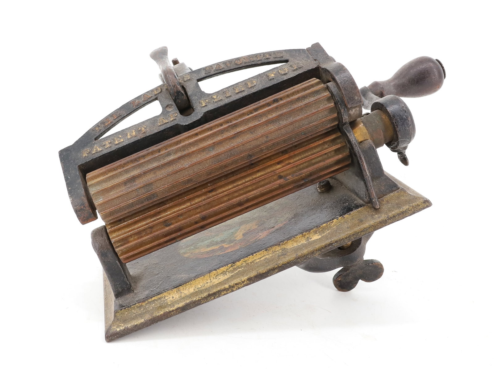THE LADIES FAVORITE FLUTING MACHINE: PAINTED CAST IRON WITH LANDSCAPE SCENE ON BASE. TOP IS MRKD. "PATENT APPLIED FOR" TWO BRASS ROLLERS 6" L. PLEASE READ CAREFULLY - ITEMS MUST BE PAID FOR THROUGH LIVE AUCTIONEERS OR WITH CASH OR CHECK 
